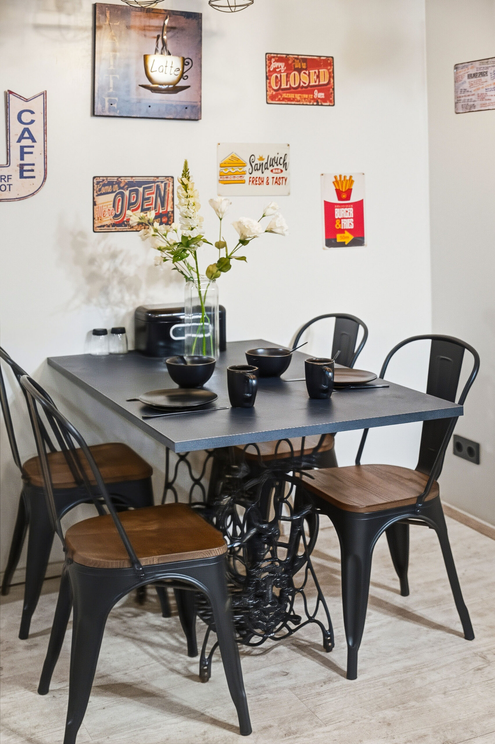 Compact dining table with black chairs and gallery wall