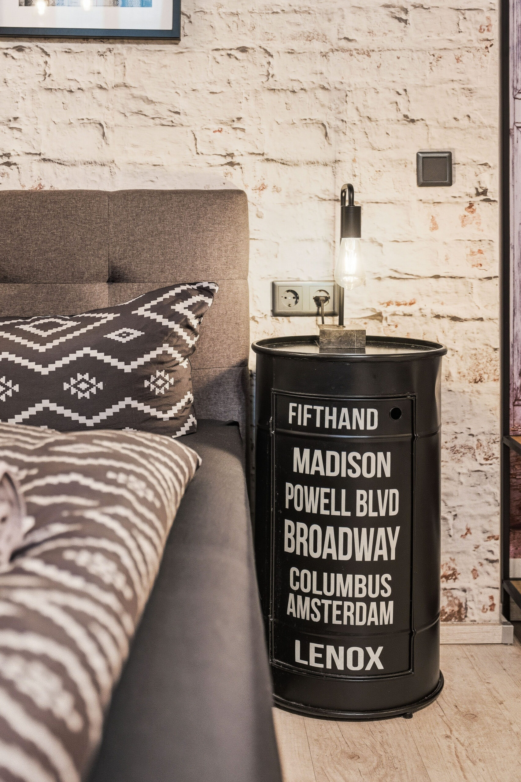 Bedside table with signage and patterned bedding detail