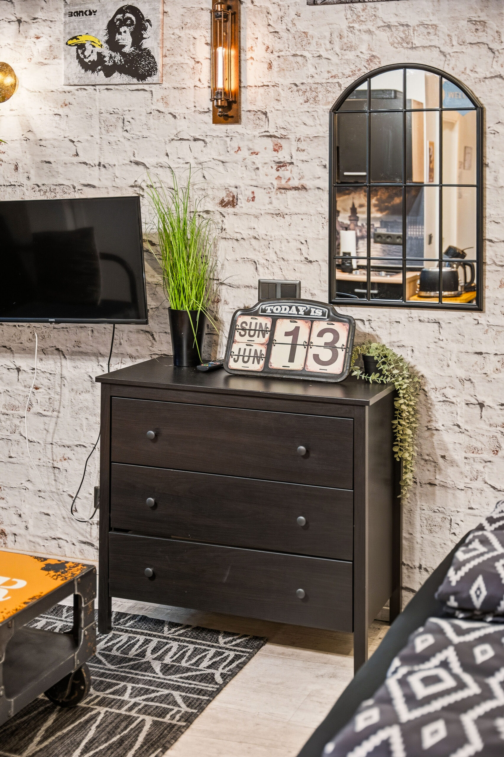 Dark dresser with decorative items and brick wall backdrop