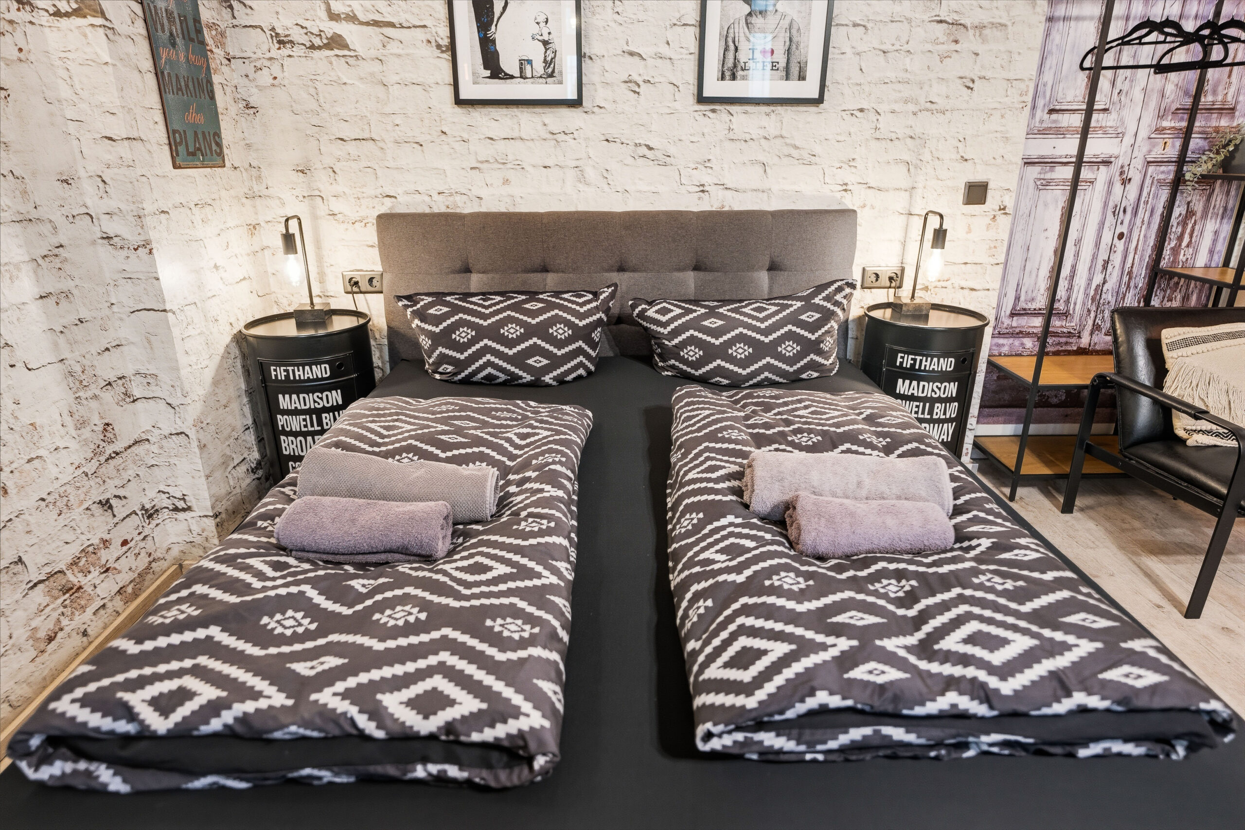 Twin beds with patterned bedding and black bedside tables