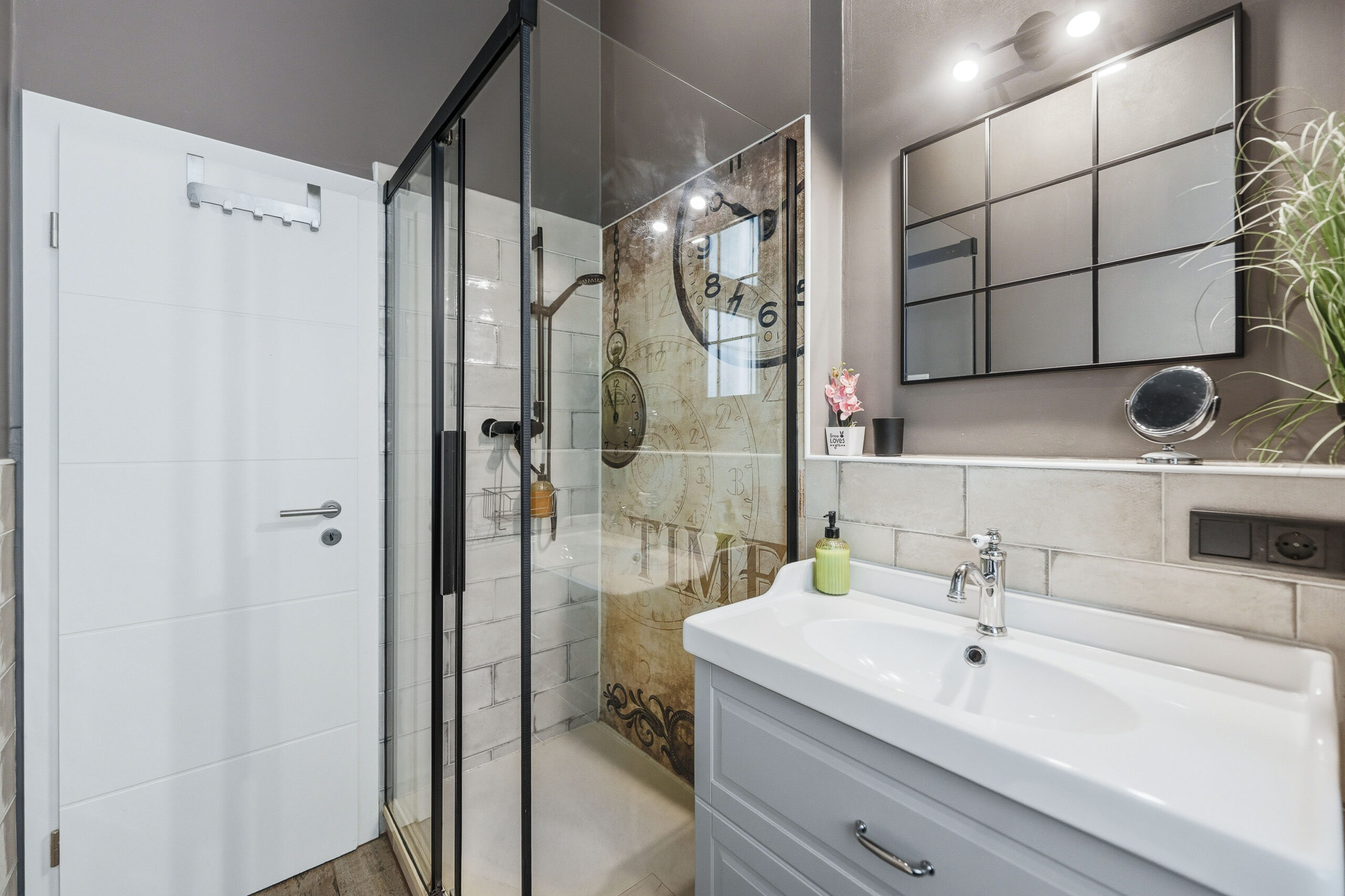 Modern bathroom with walk-in shower, double vanity and subtle time-themed wall