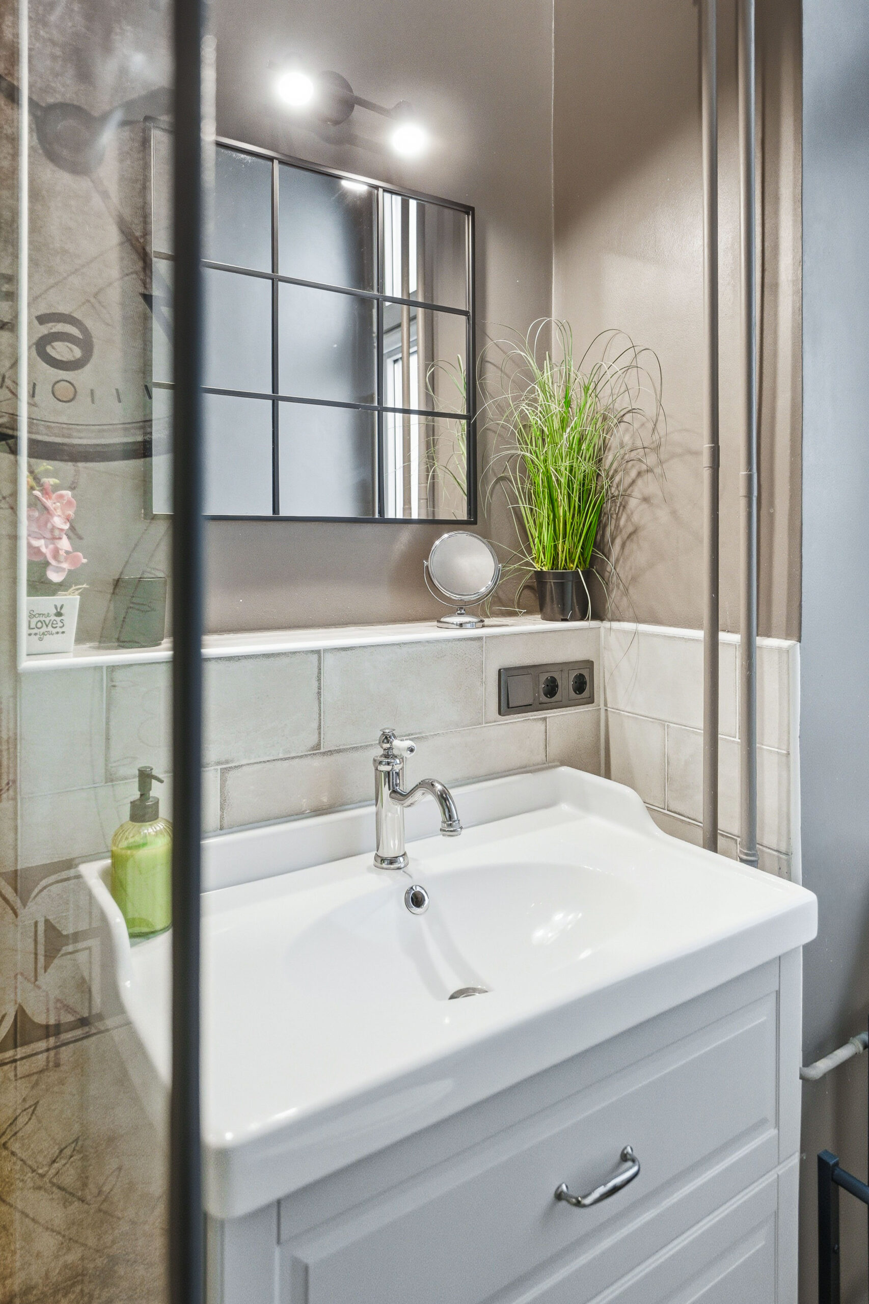 Bright bathroom with white vanity, mirror and potted plant detail