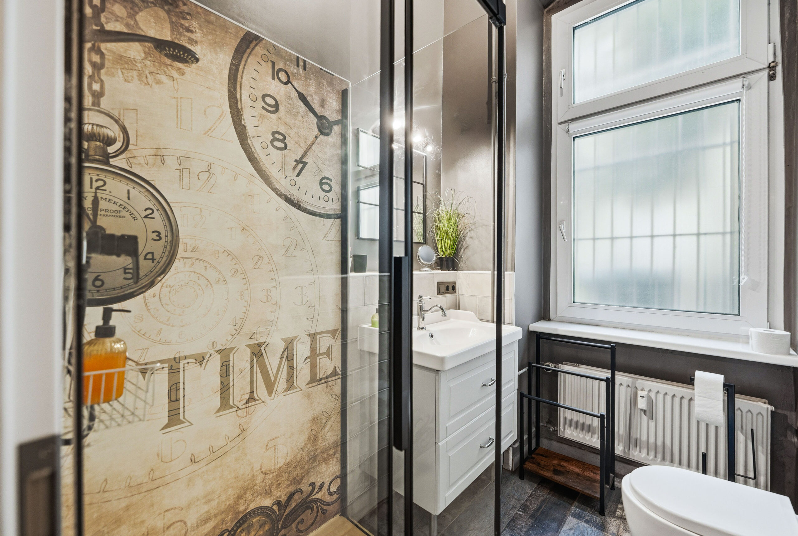 Modern bathroom entrance with frosted glass door and decorative signage