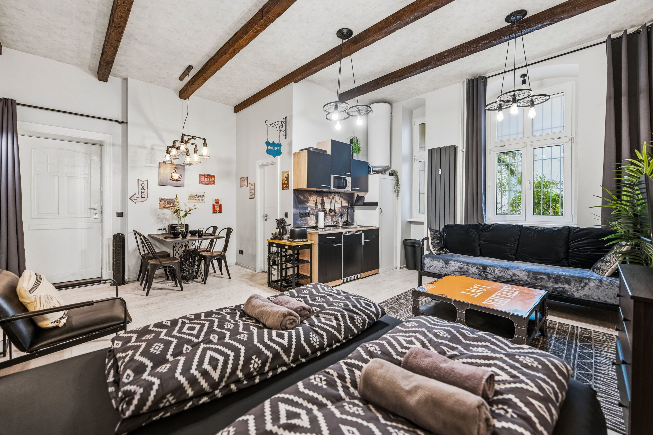 Spacious bedroom with exposed beams, zebra bedding and brick walls