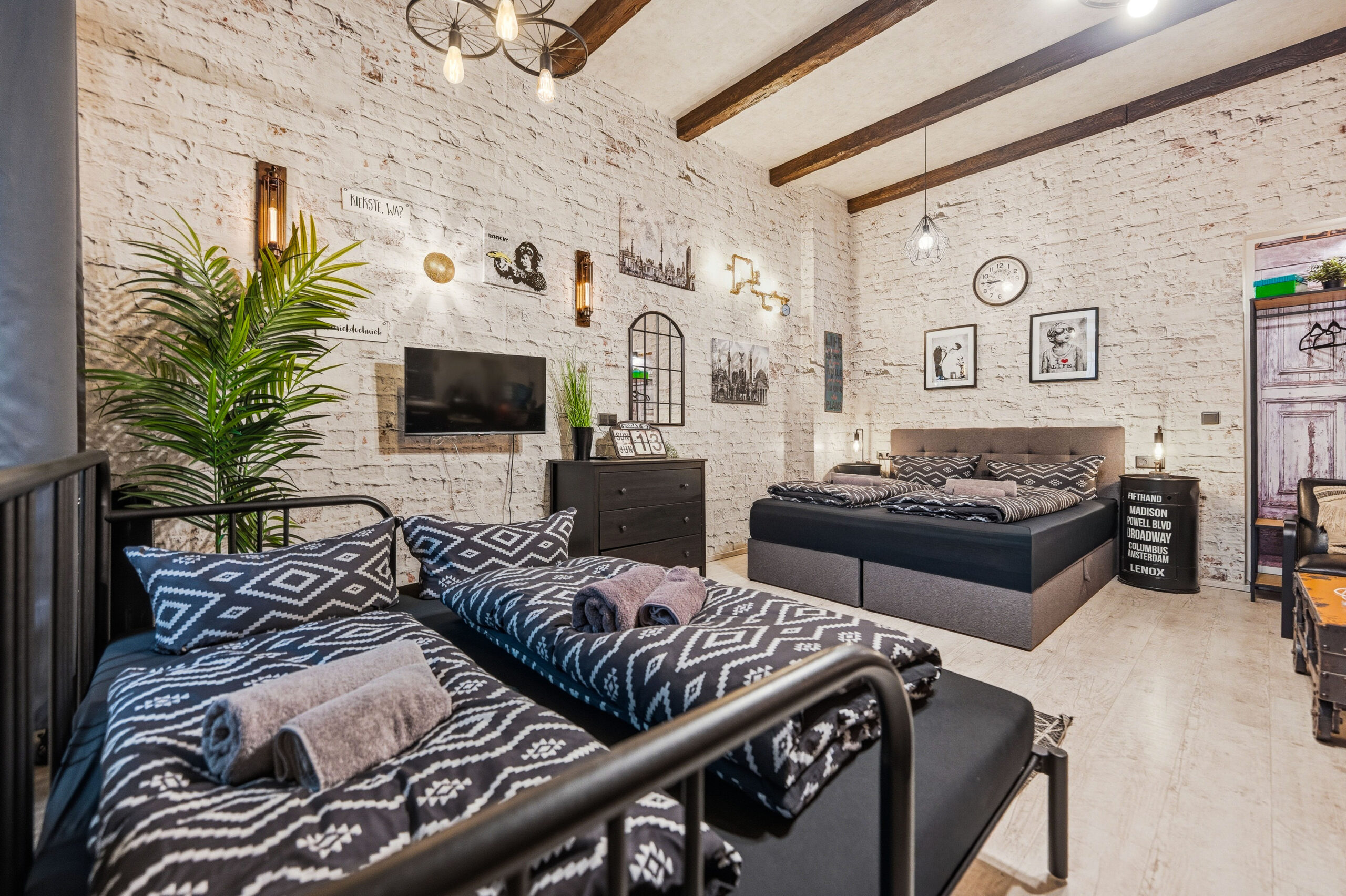 Modern loft bedroom with zebra pattern bedding and industrial brick walls