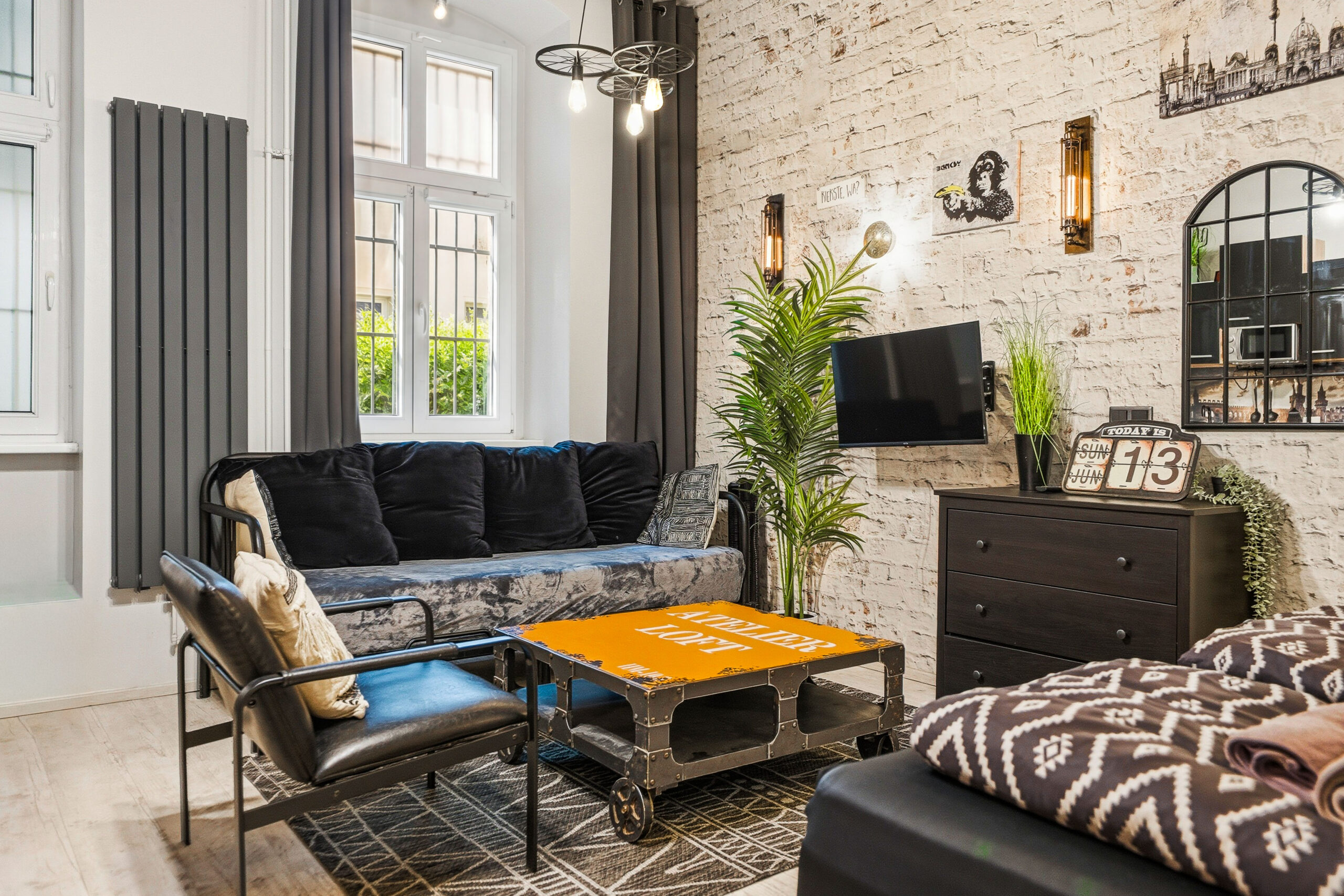 Industrial loft living room with high ceilings, brick walls and large windows