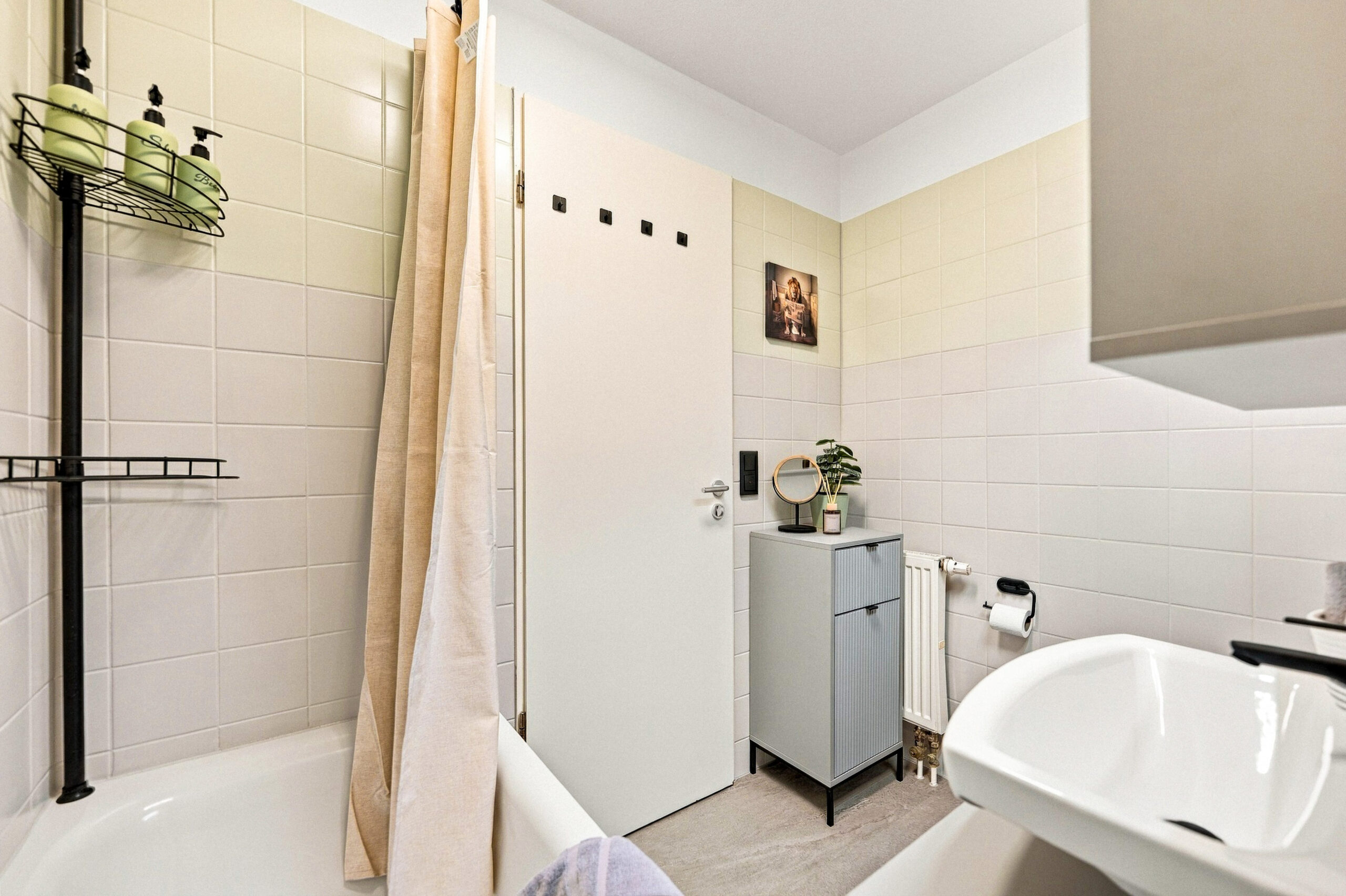 Bathtub area with towel rail and shelving unit