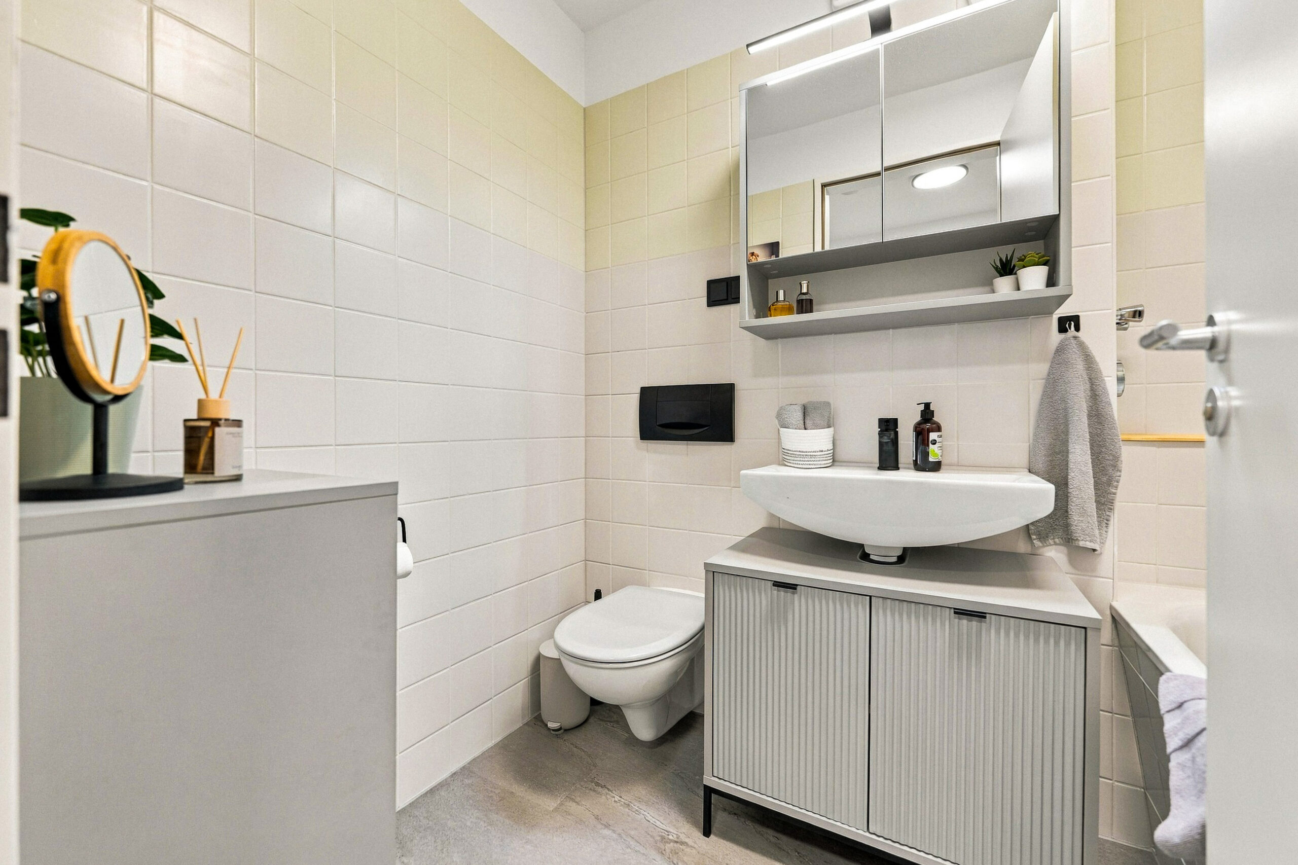Bathroom with sink, toilet, and tiled walls
