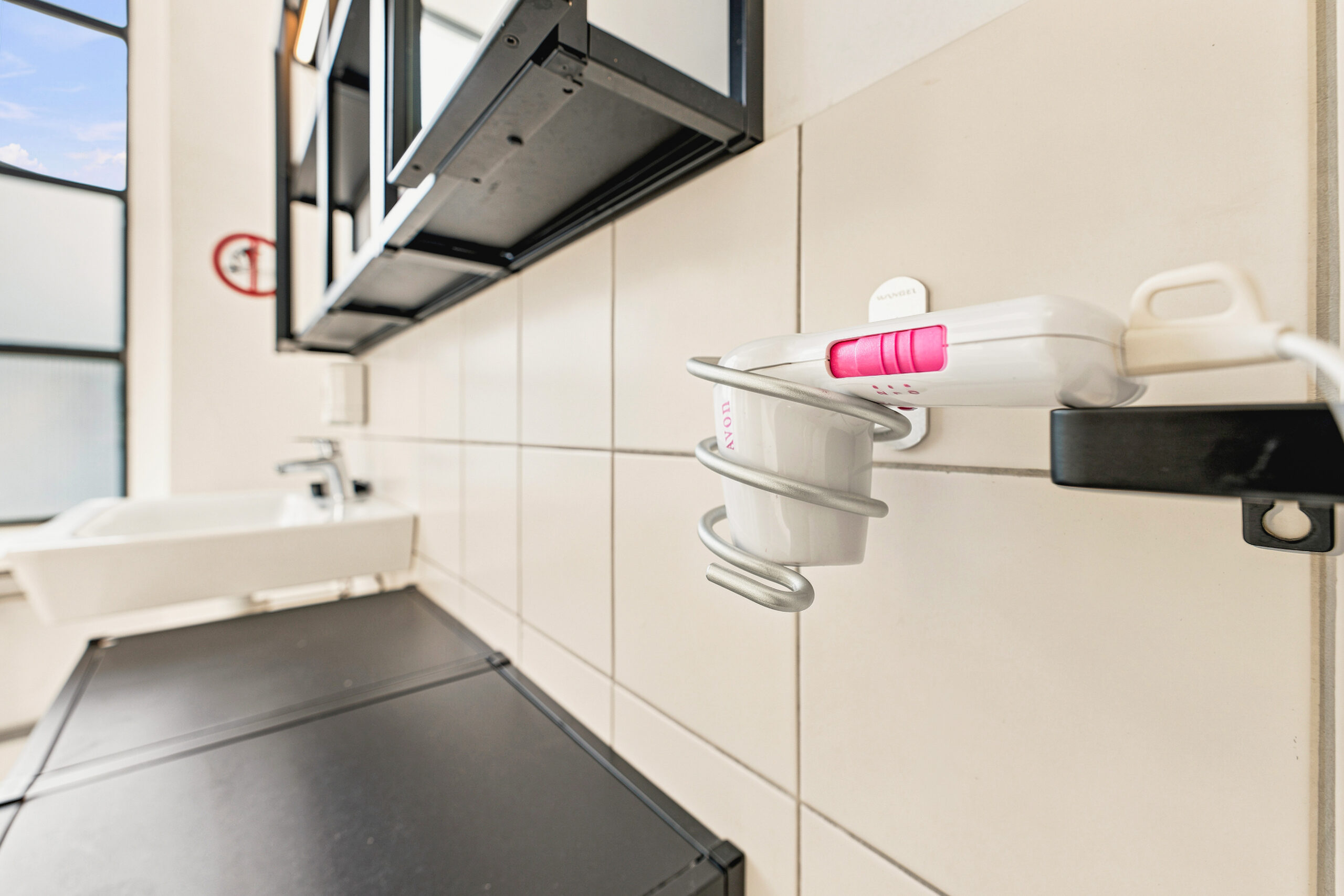Small kitchen galley with black stovetop and shelving