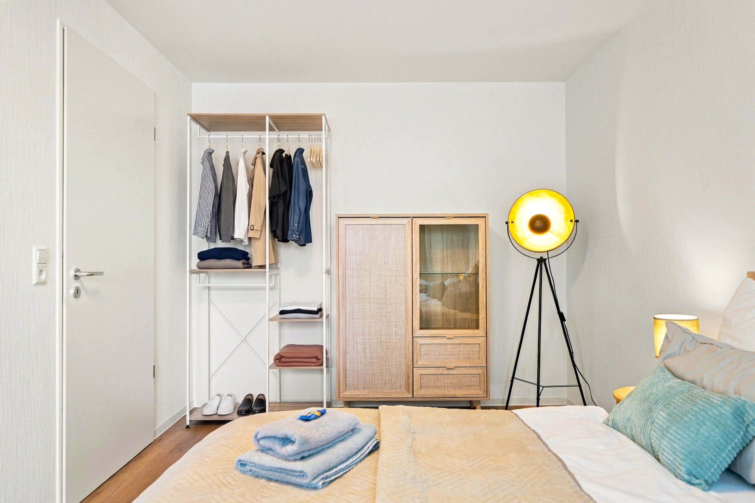 Bedroom corner with clothing rack and cabinet