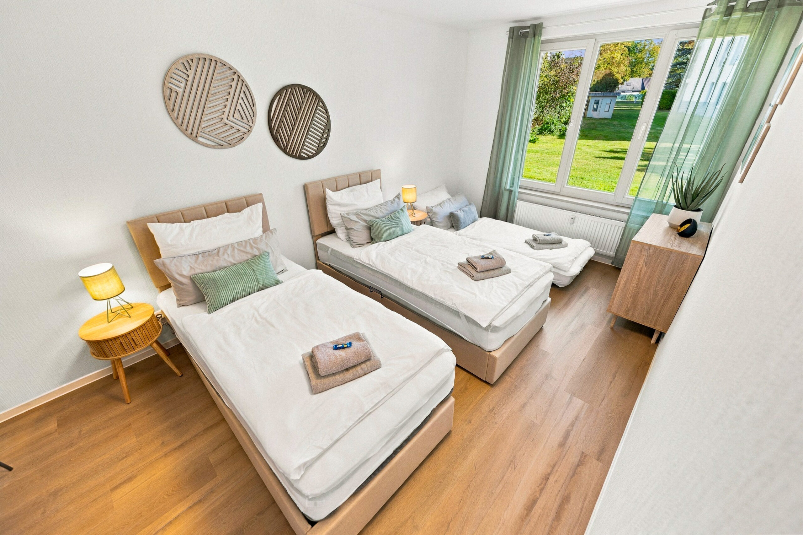 Twin beds with wooden floor and large window