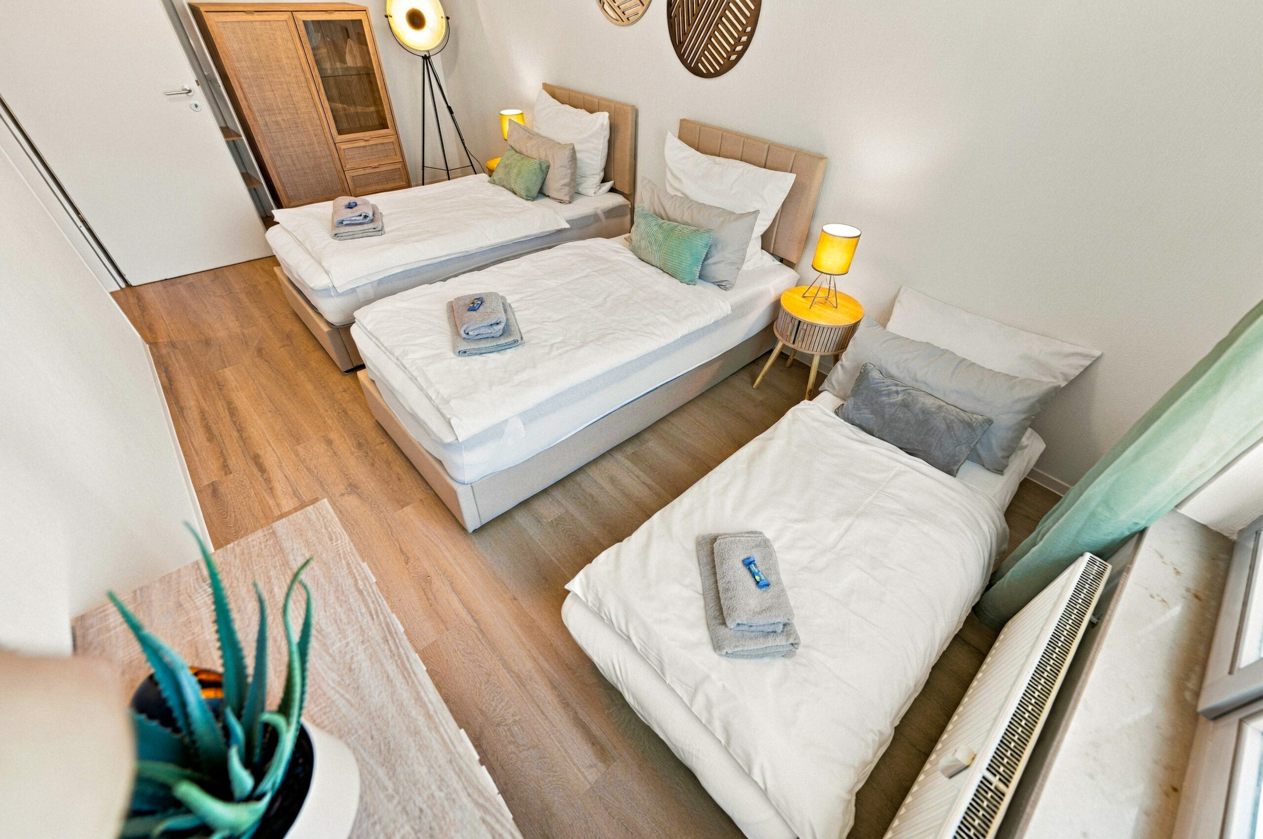 Twin beds in bright bedroom with wooden accents