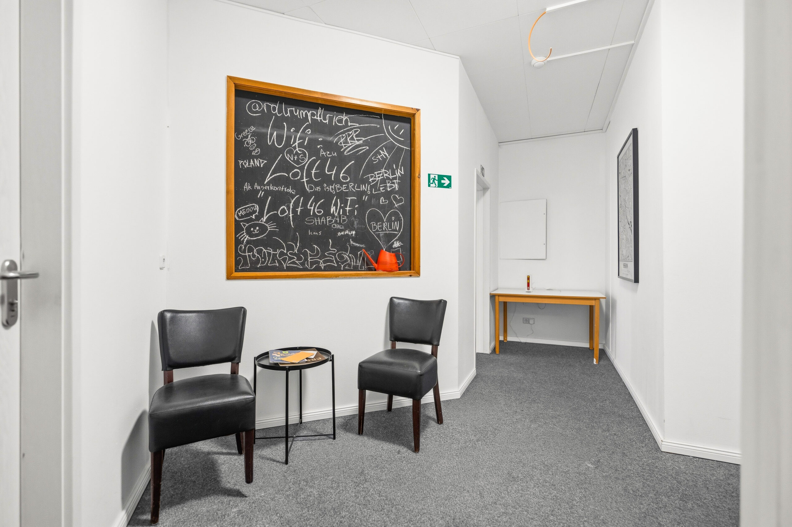 Hallway seating area with chalkboard and two armchairs