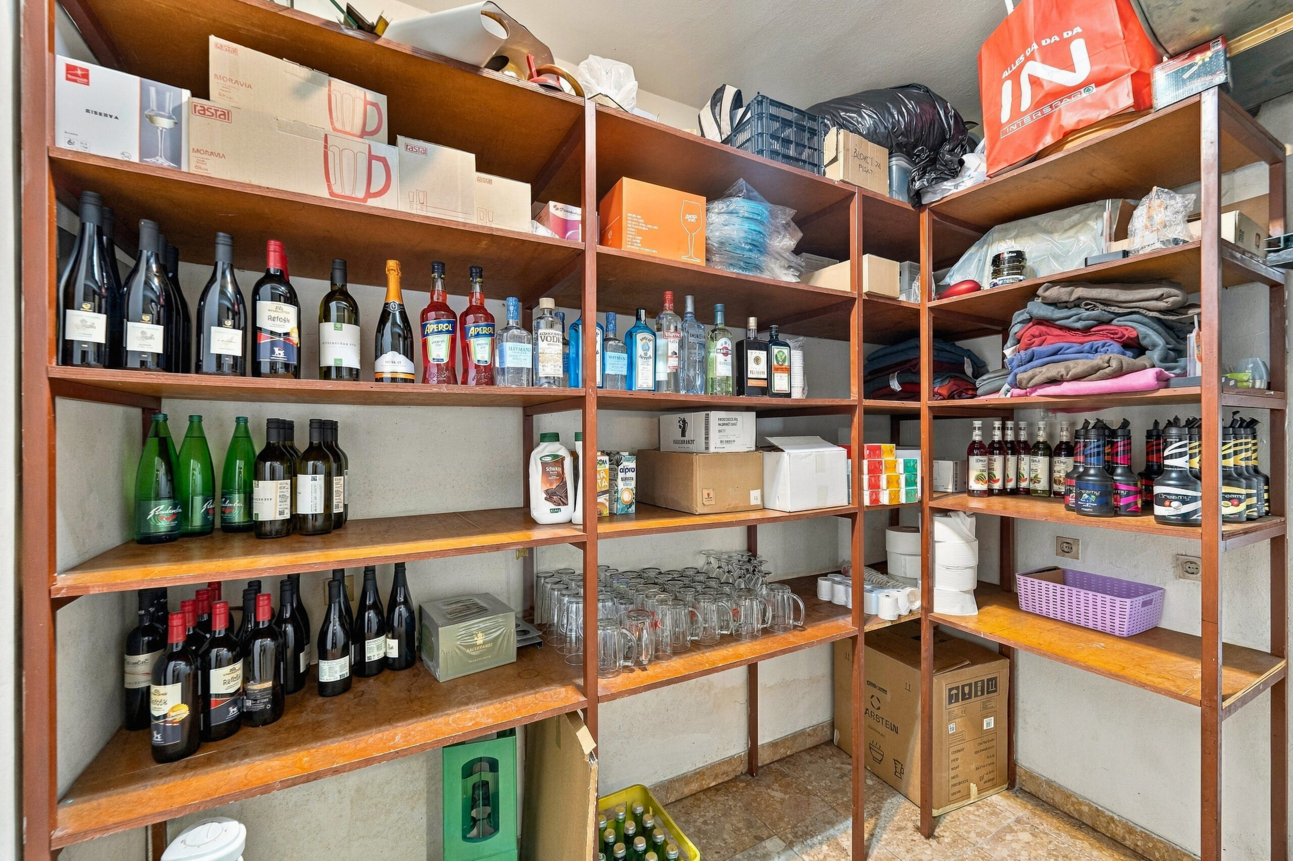 Storage shelving with wine bottles and supplies