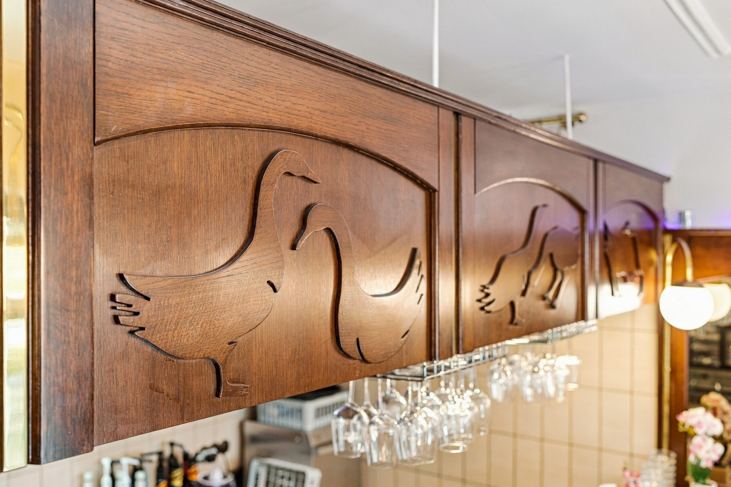 Carved wood cabinet detail above wine glasses