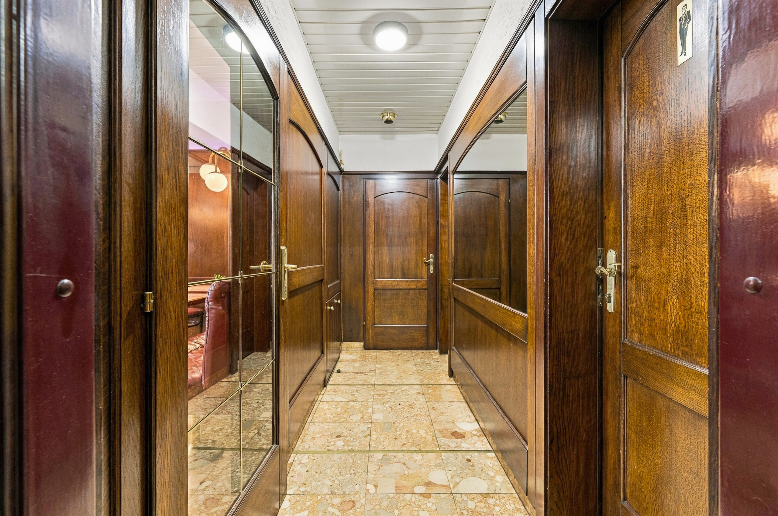 Wood paneled corridor with multiple doors