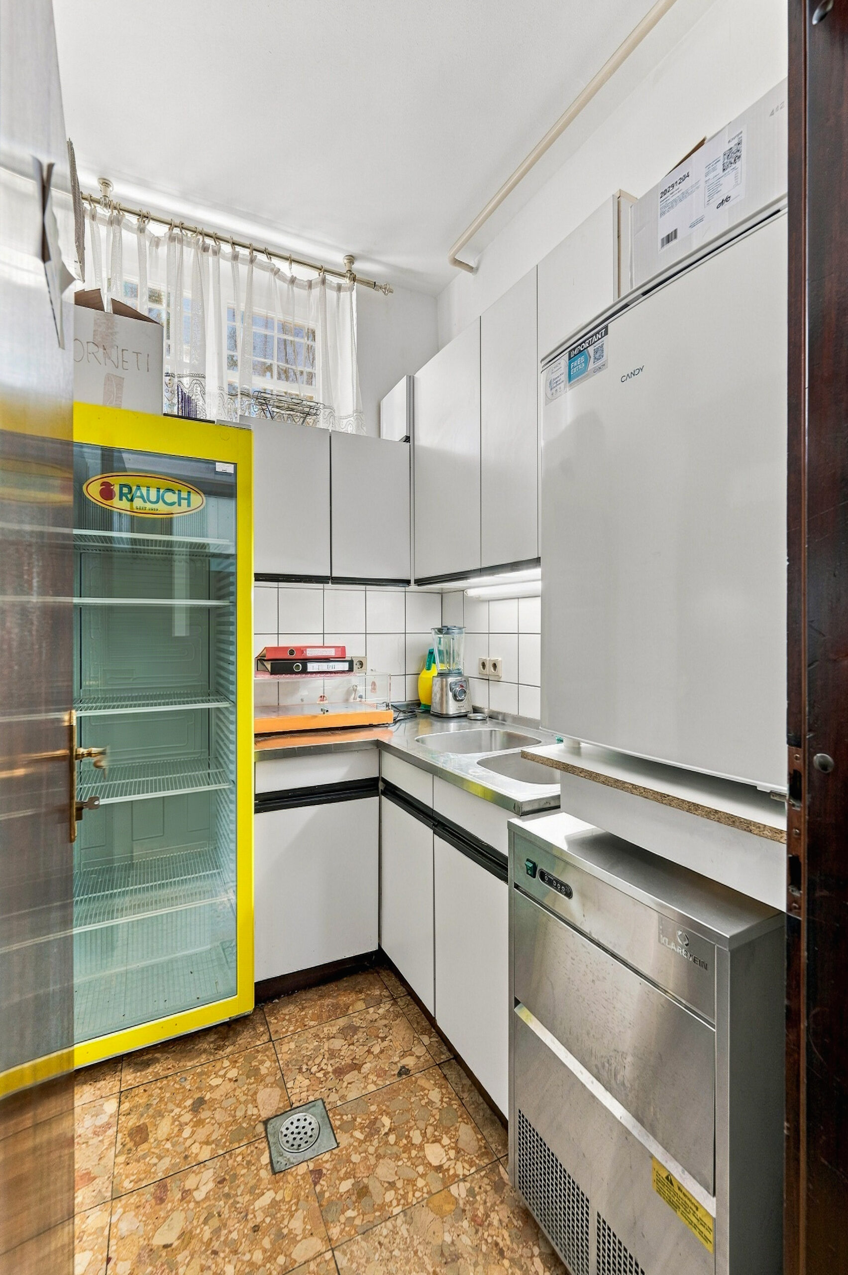 Compact kitchen with white cabinets and appliances