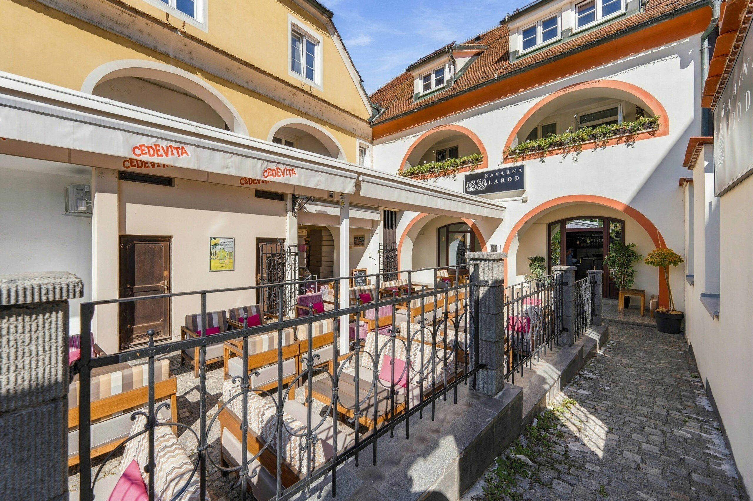 Cobblestone courtyard terrace with arched walkway