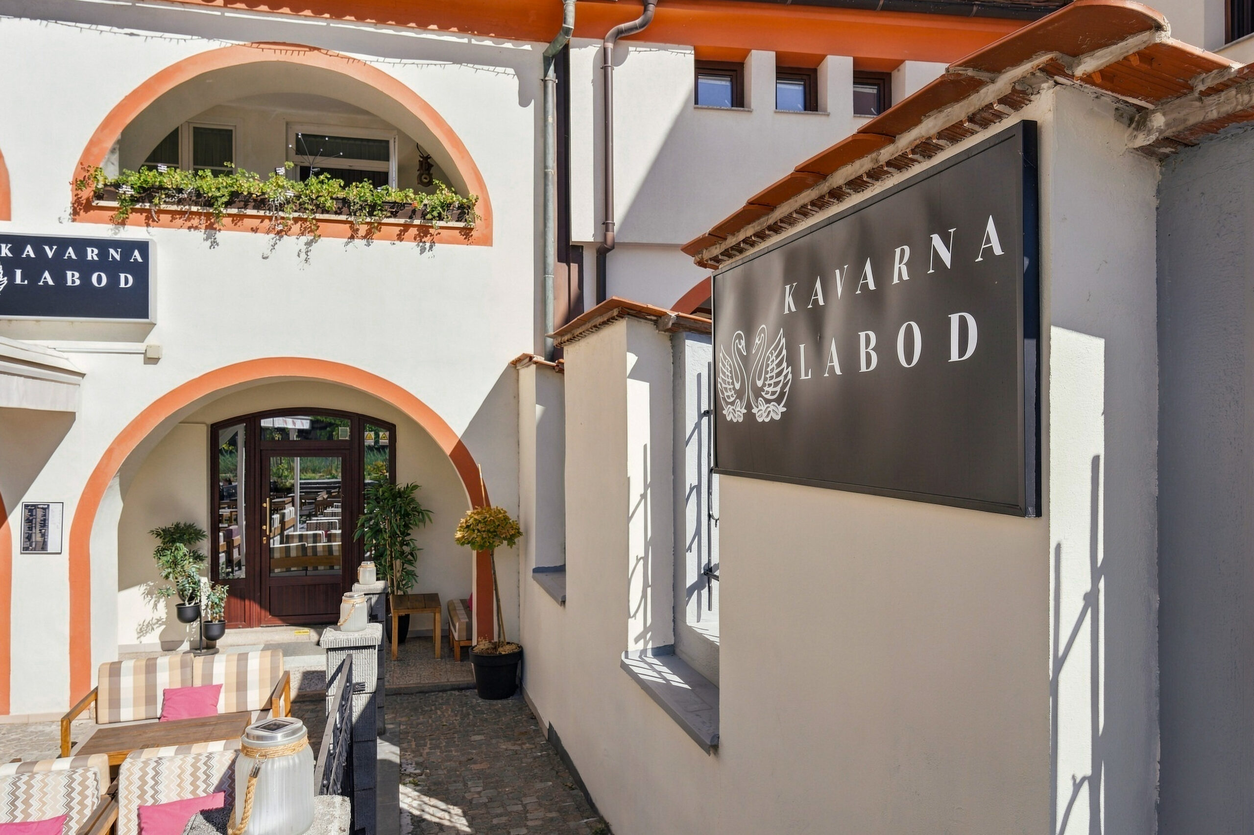 Cafe entrance signage with terrace seating