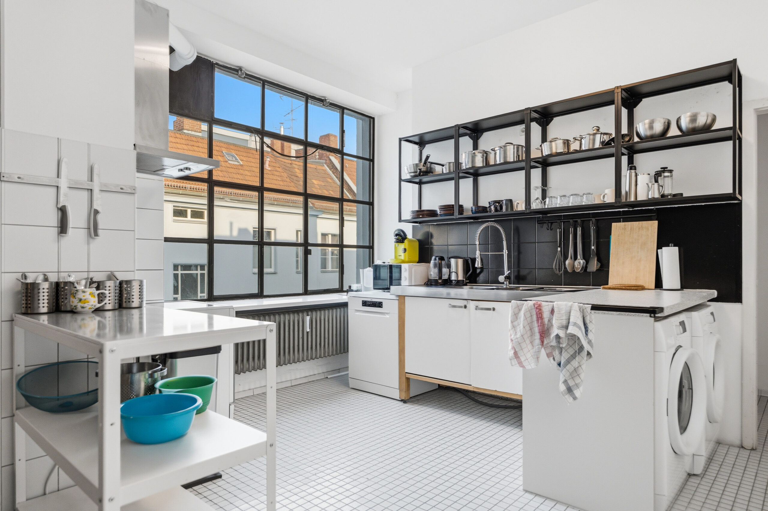 Bright laundry room with black shelving and washing machine