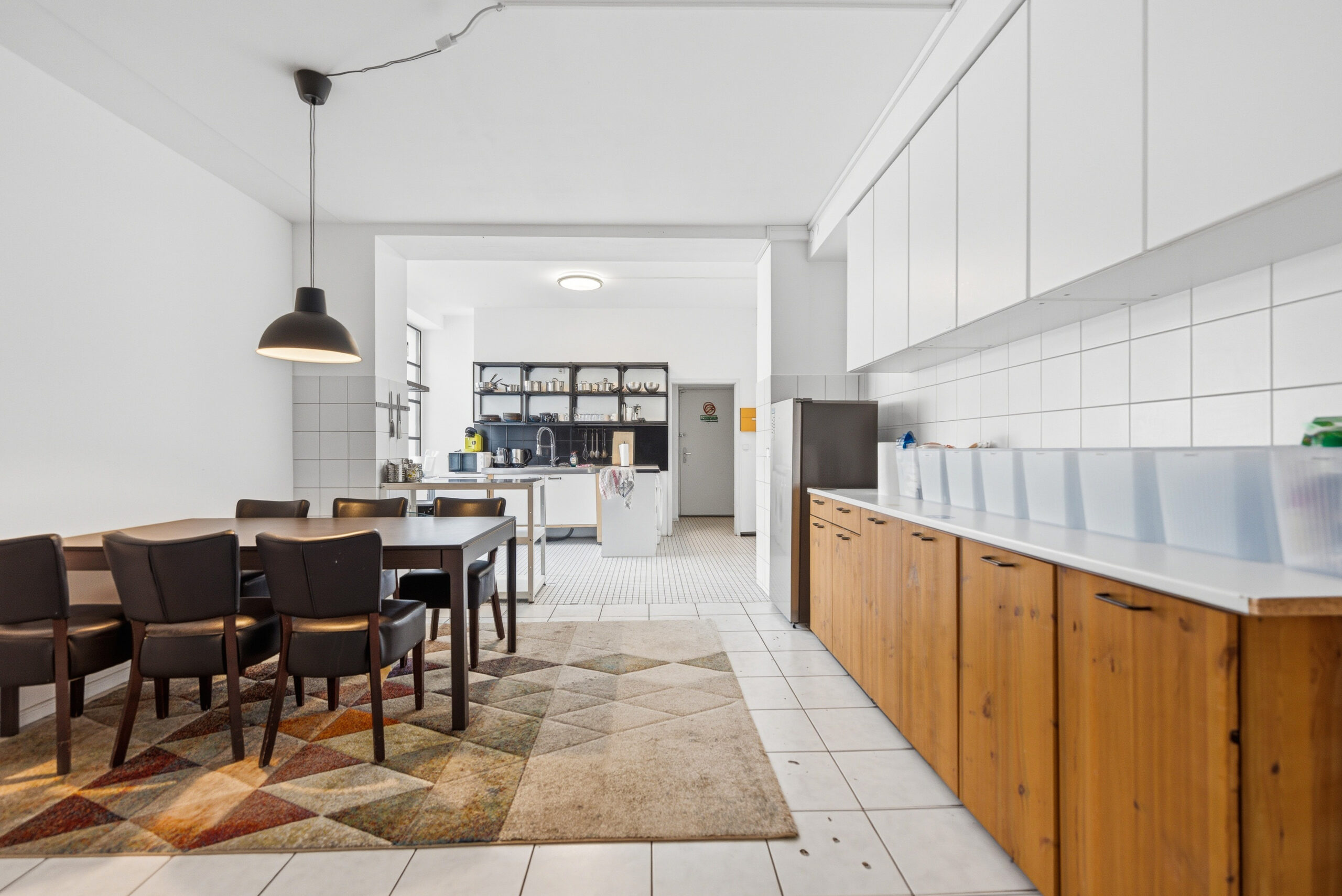 Spacious open-plan living area with wooden kitchen cabinetry