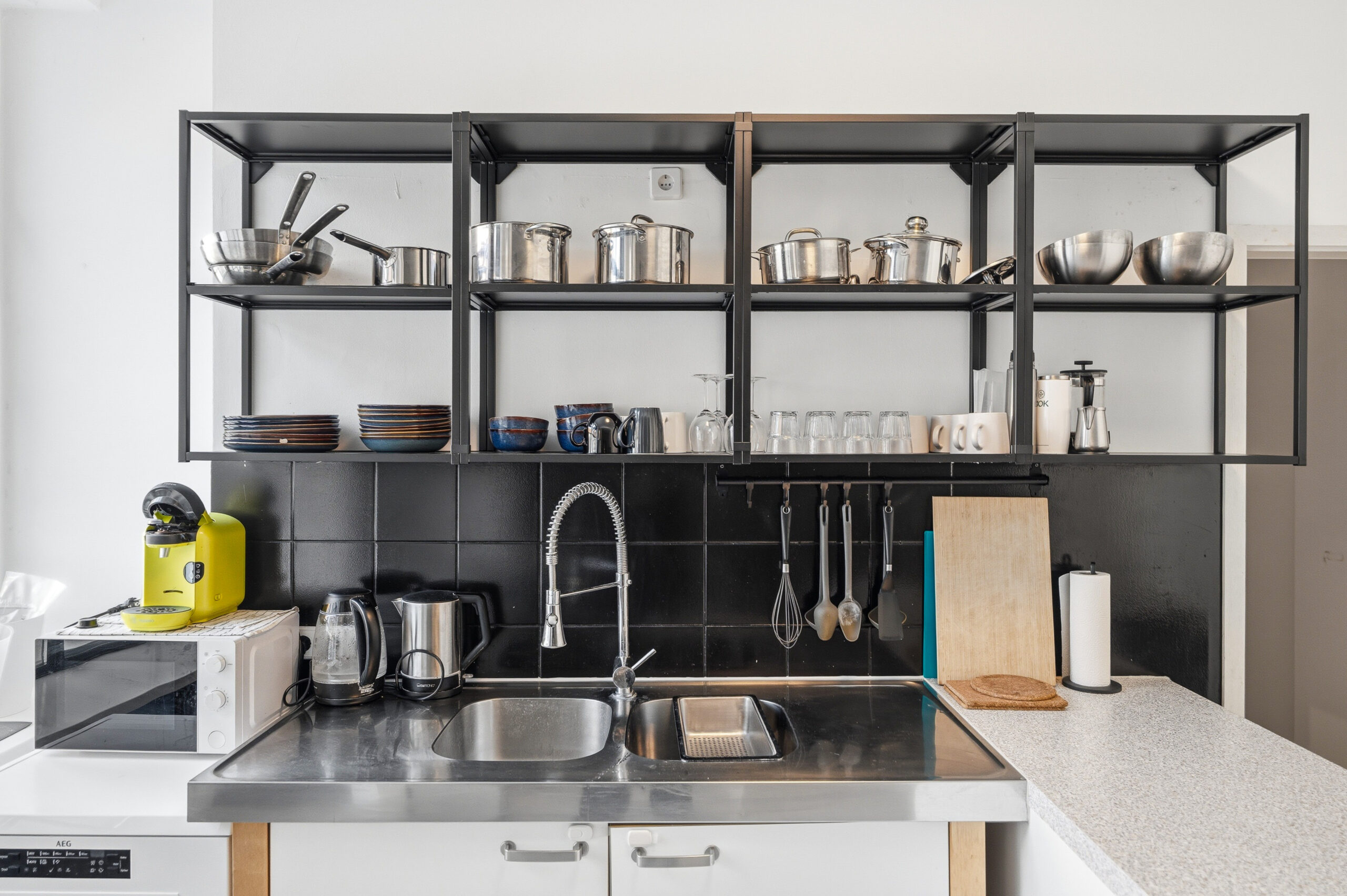 Industrial kitchen with sink and open shelving system