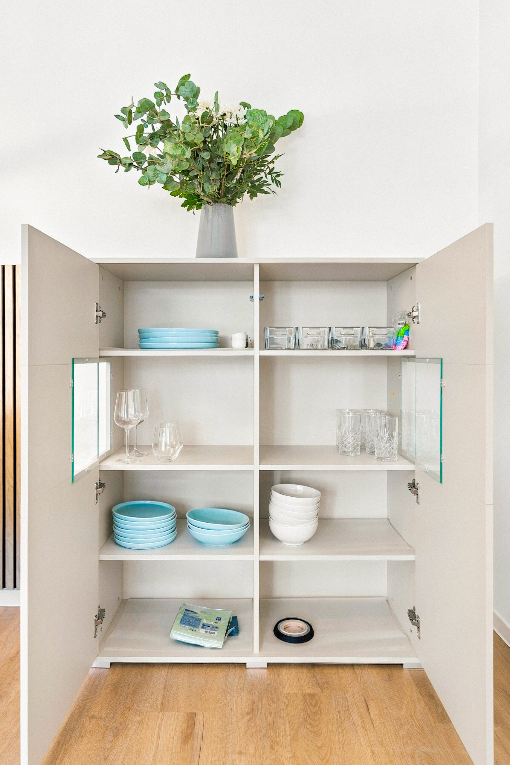 Open cabinet with dishes and glassware