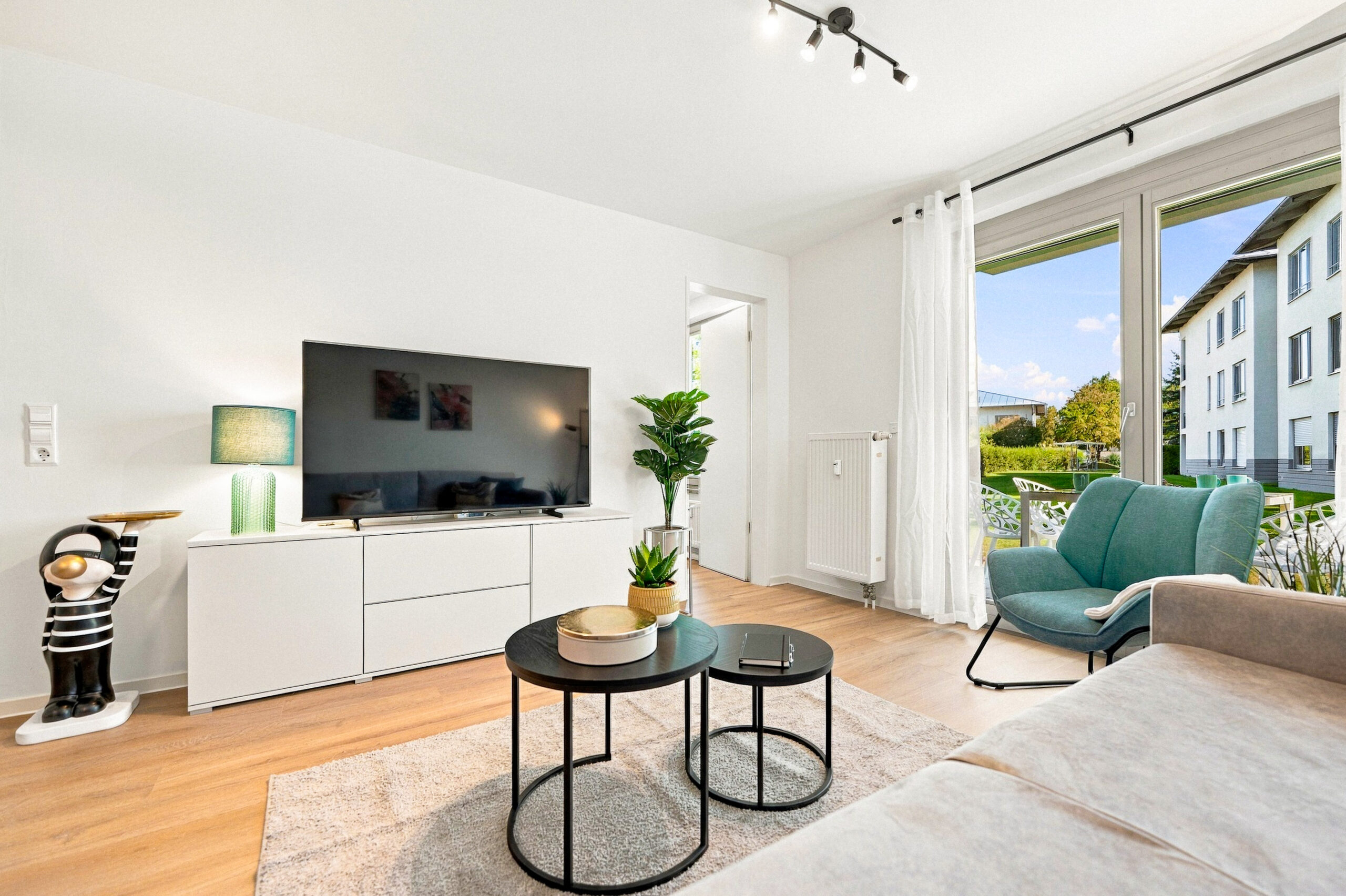 Living room with TV console and balcony access