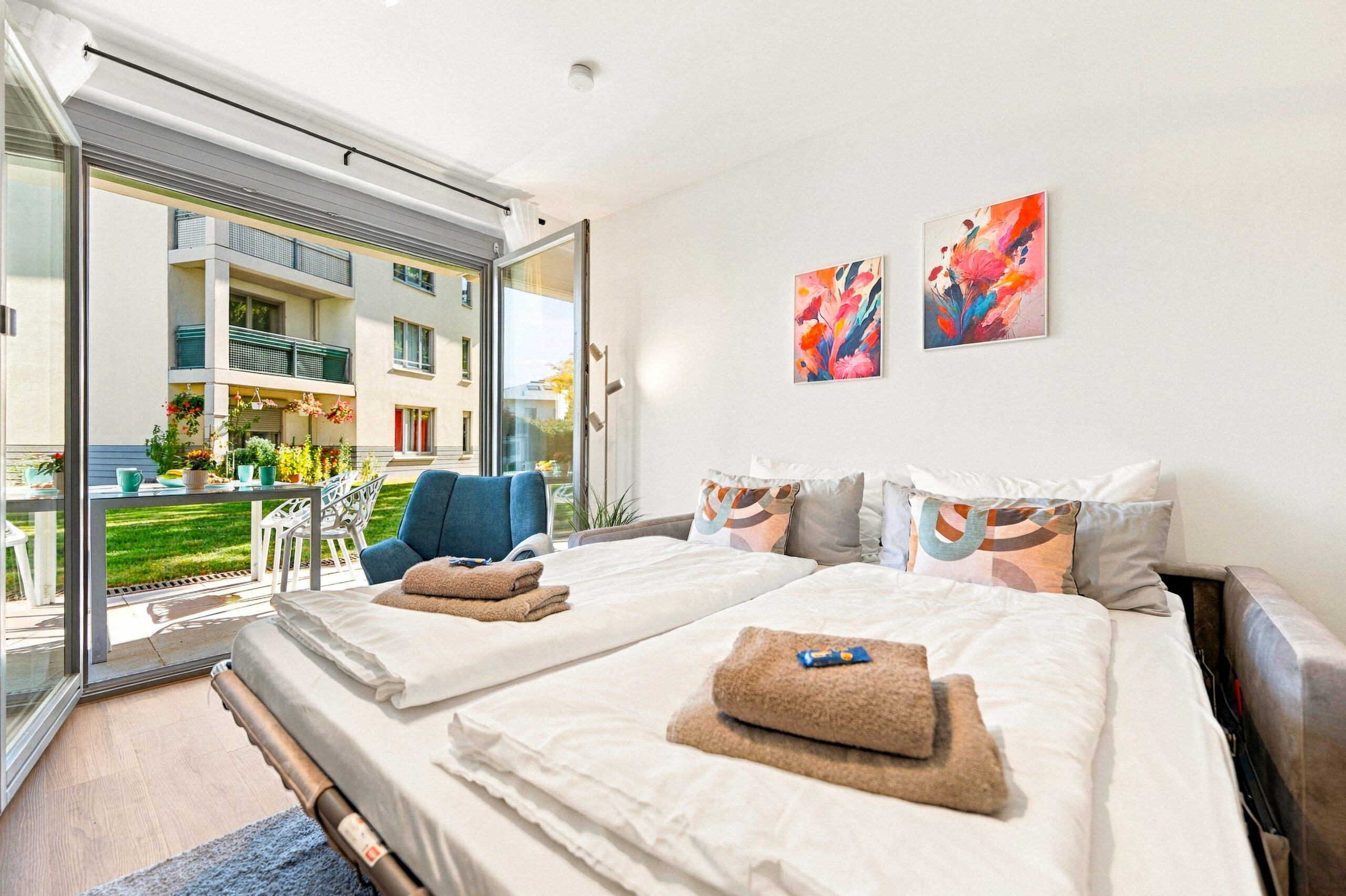 Twin bed setup with balcony view and artwork