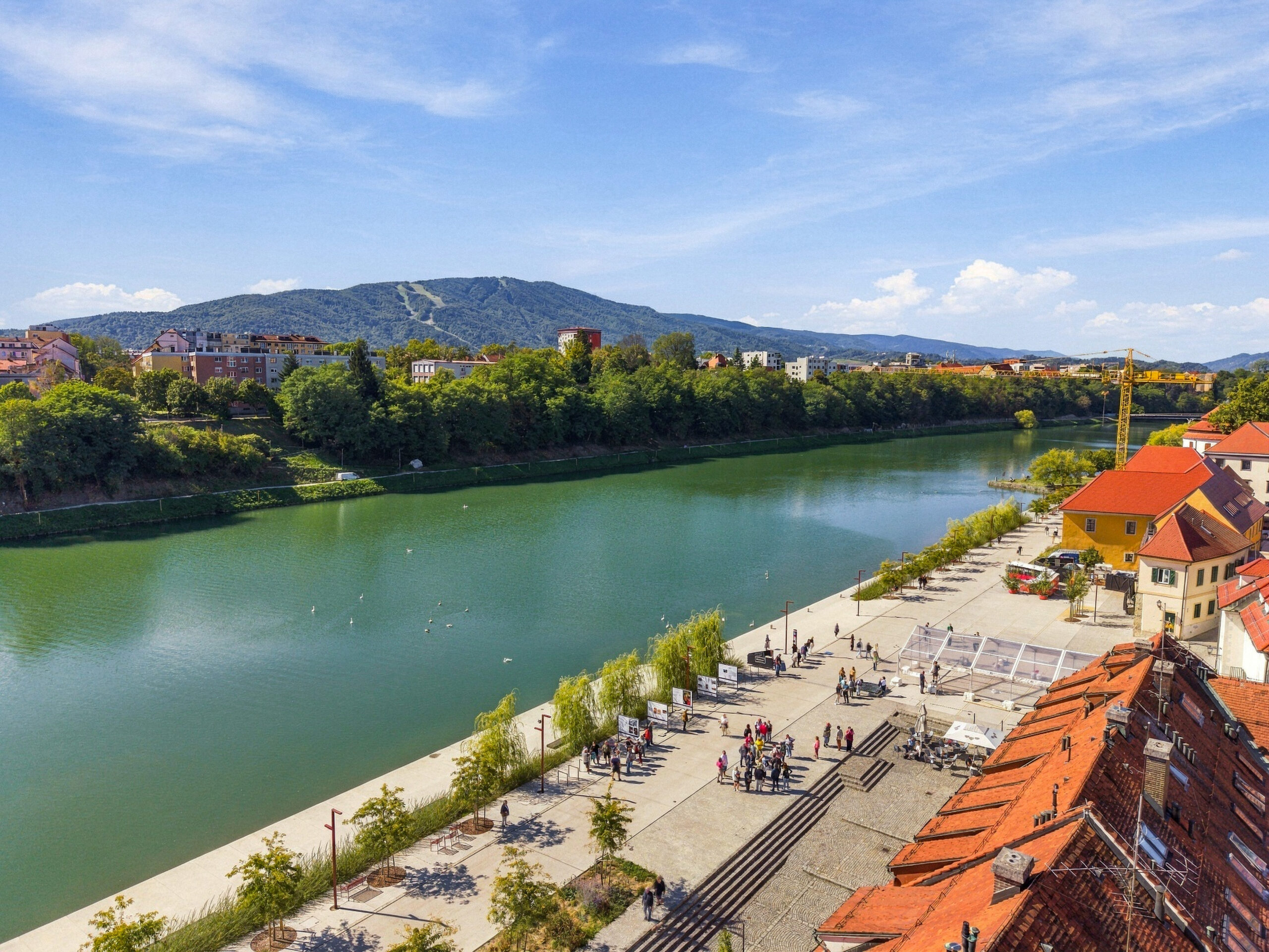 Aerial view of river and riverside promenade with hills