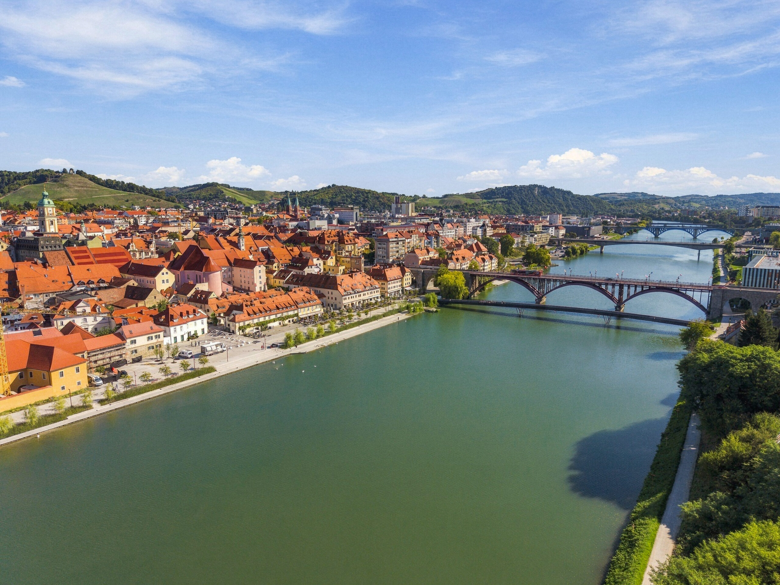 Aerial view of riverside town with bridges and hills