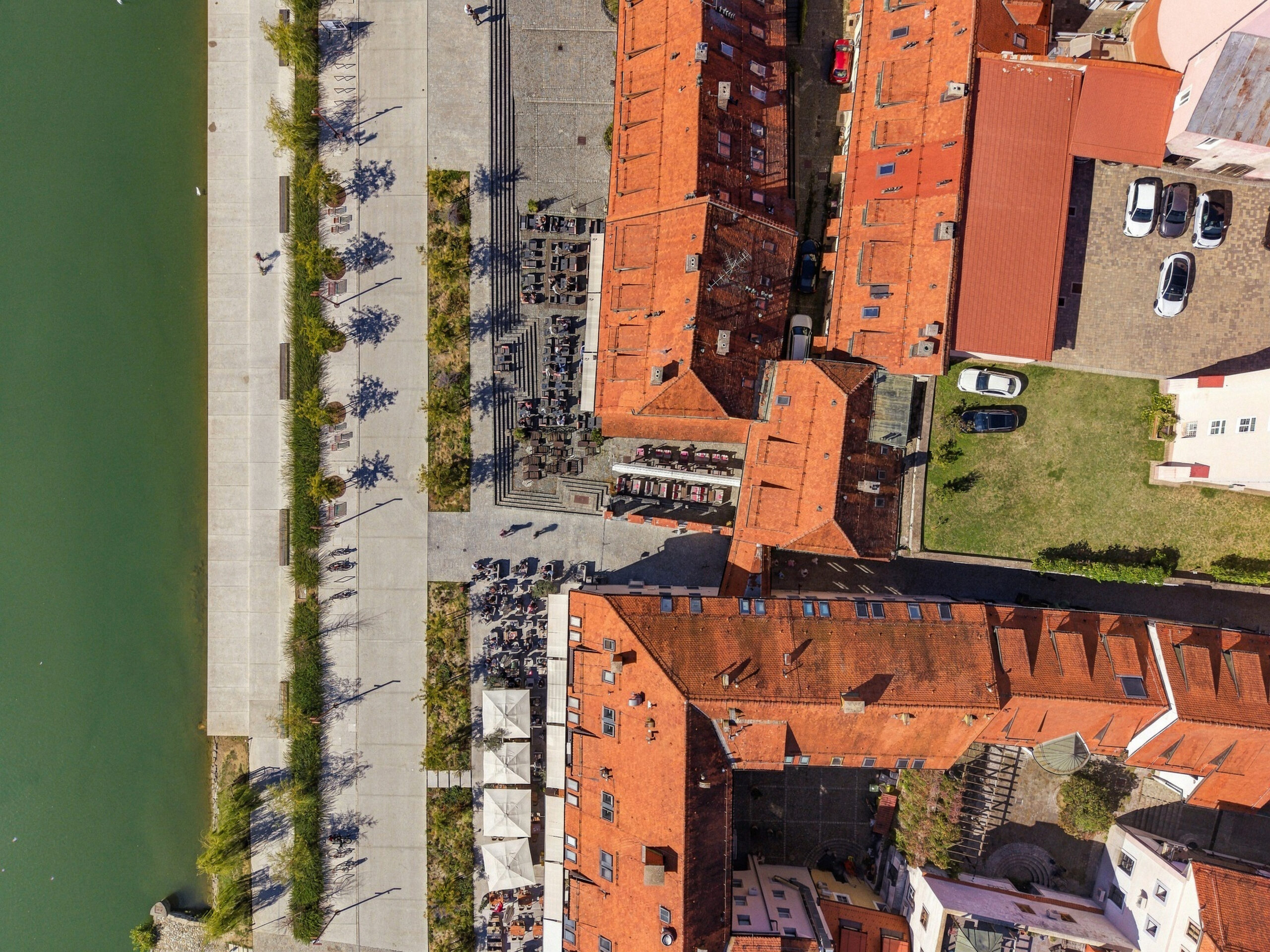 Top-down aerial view of riverside promenade and rooftops