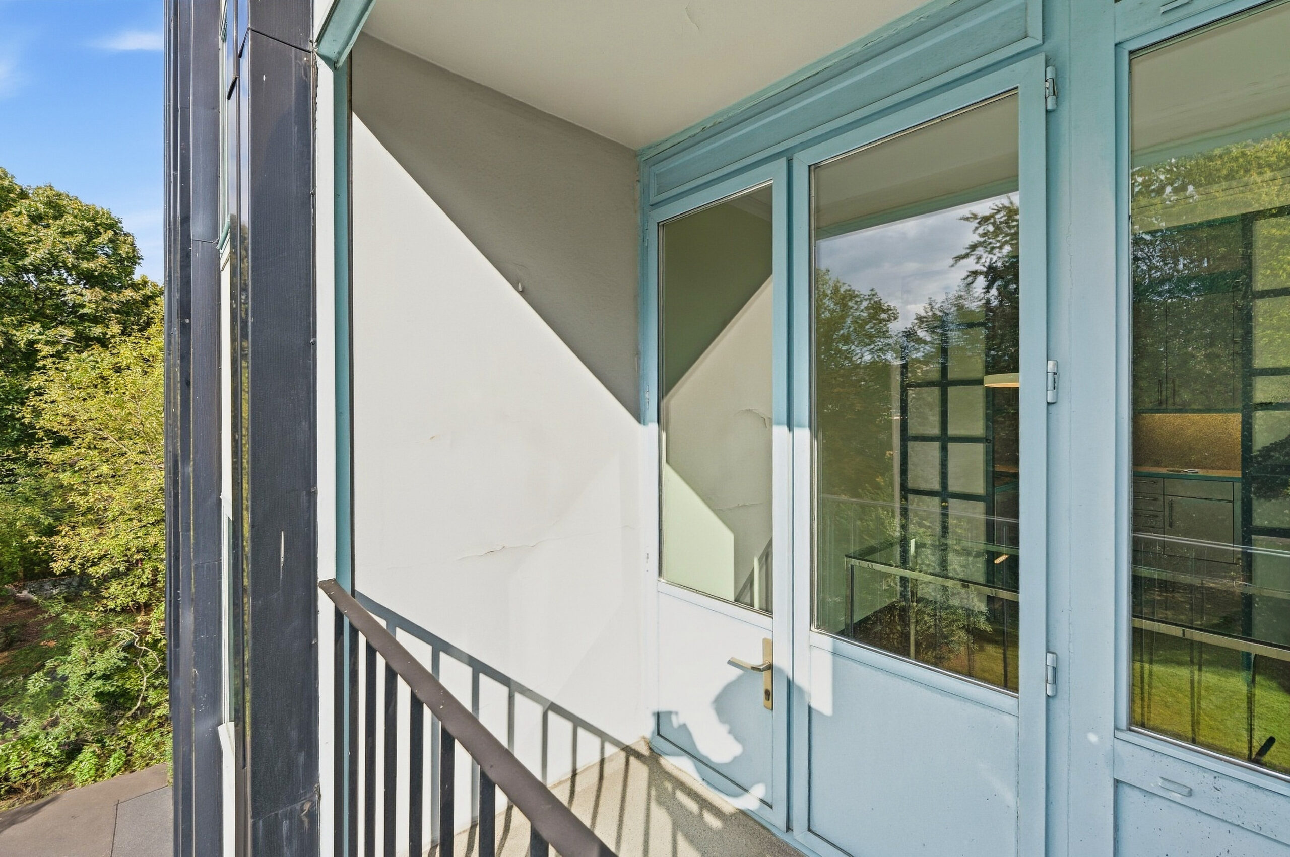 Balcony corner with blue-framed doors