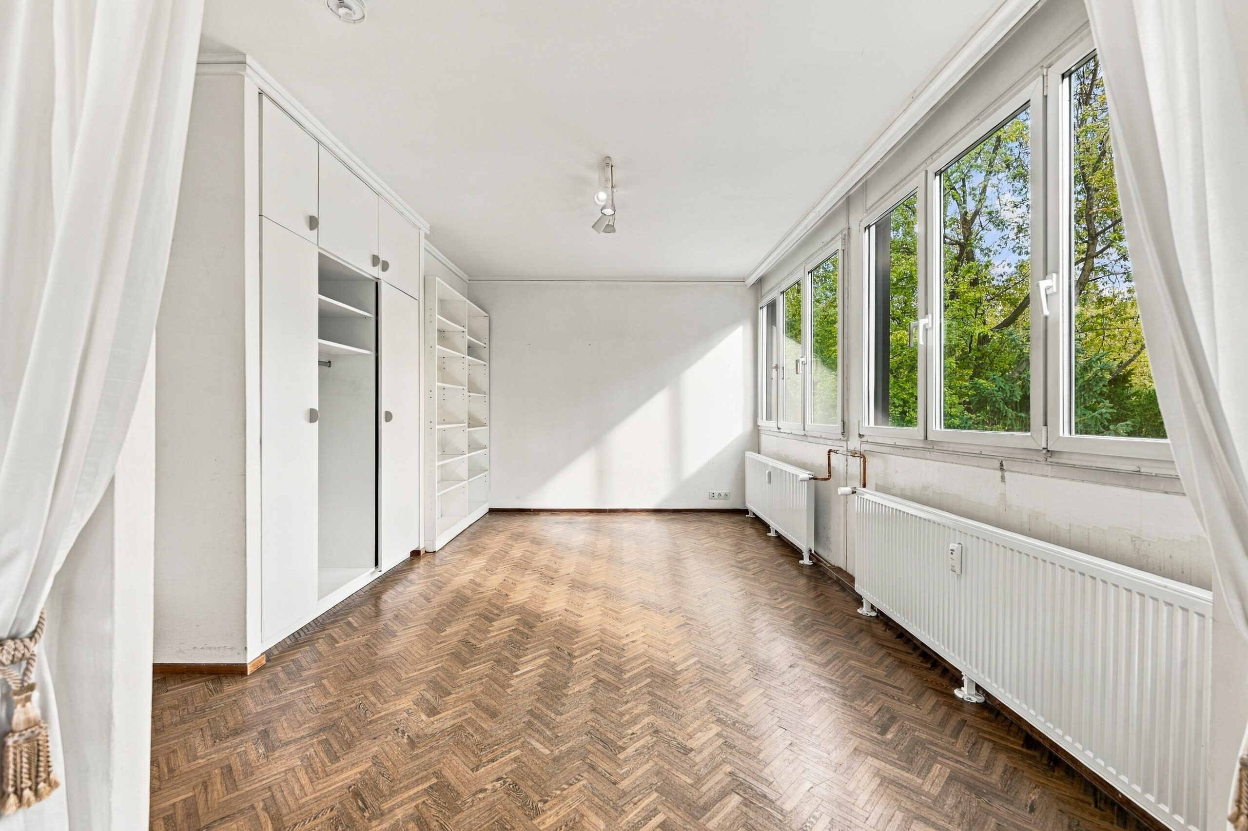 Bright room with built-in white cabinets and windows