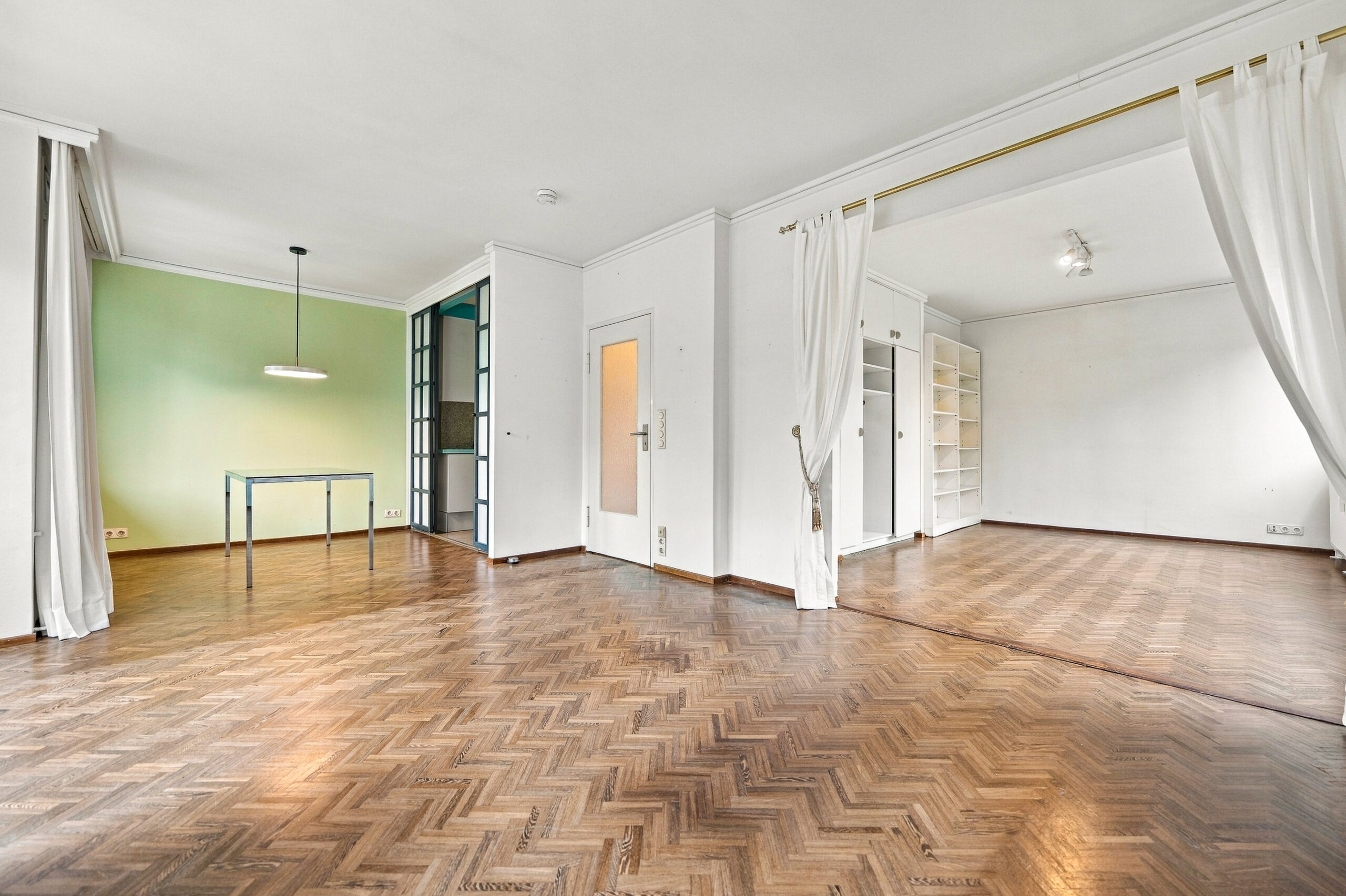 Bright living room with parquet floor and green accent