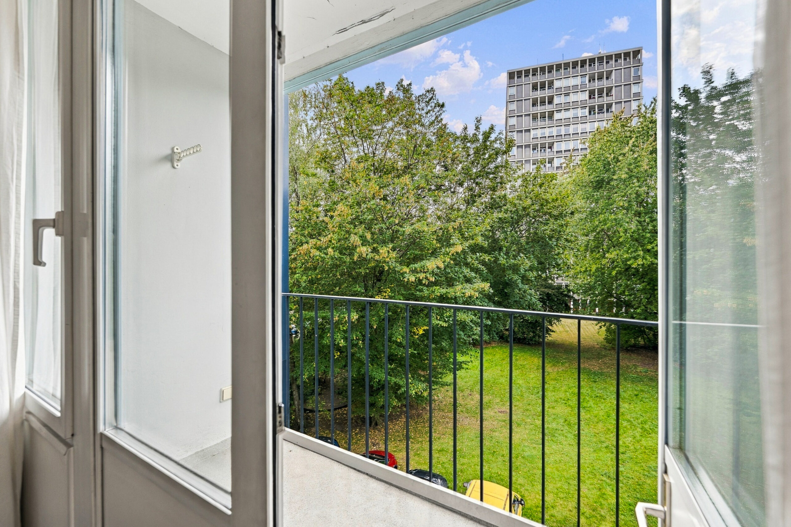 View from balcony overlooking green trees and tower