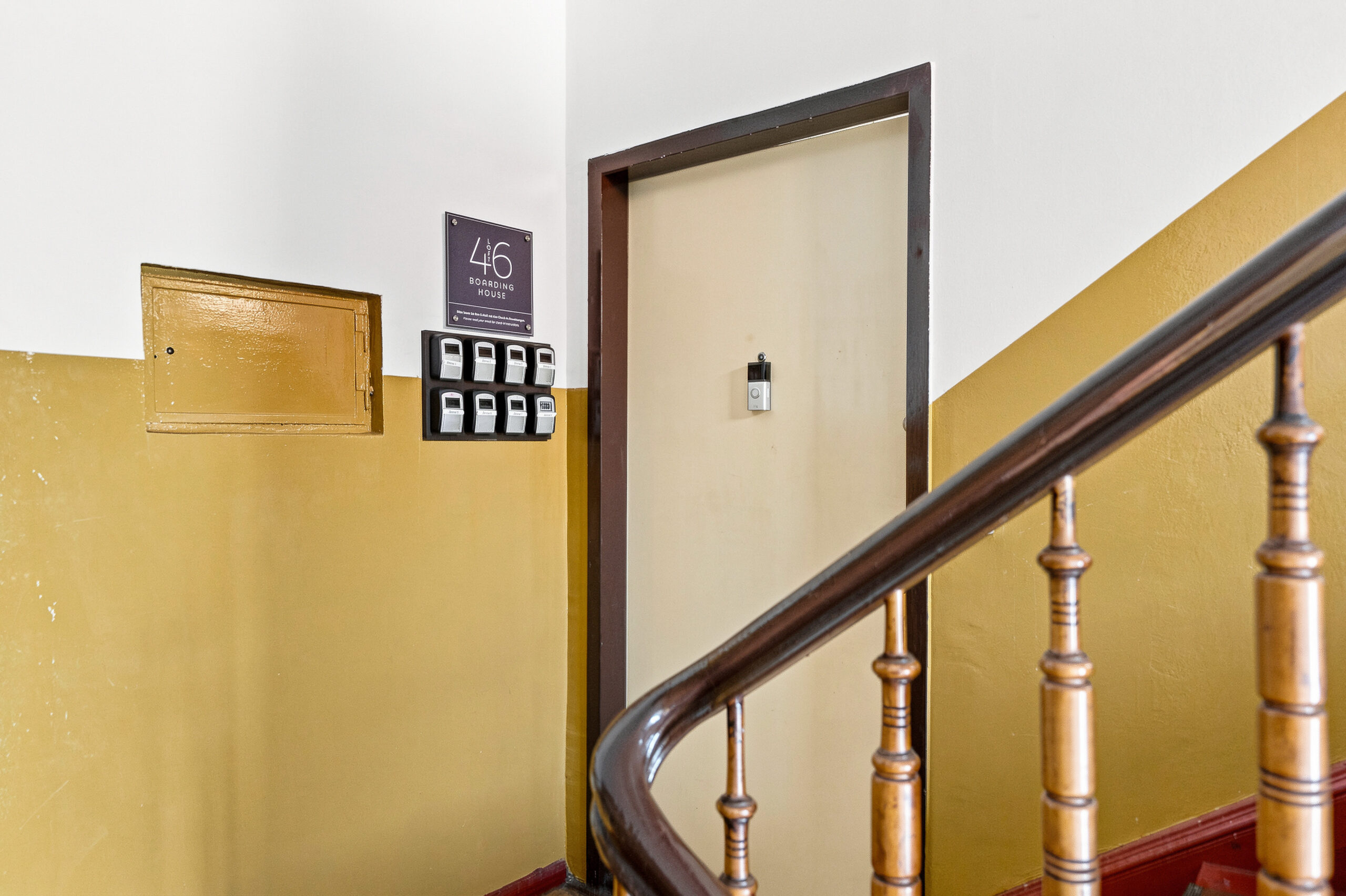 Staircase with yellow walls and wooden bannister