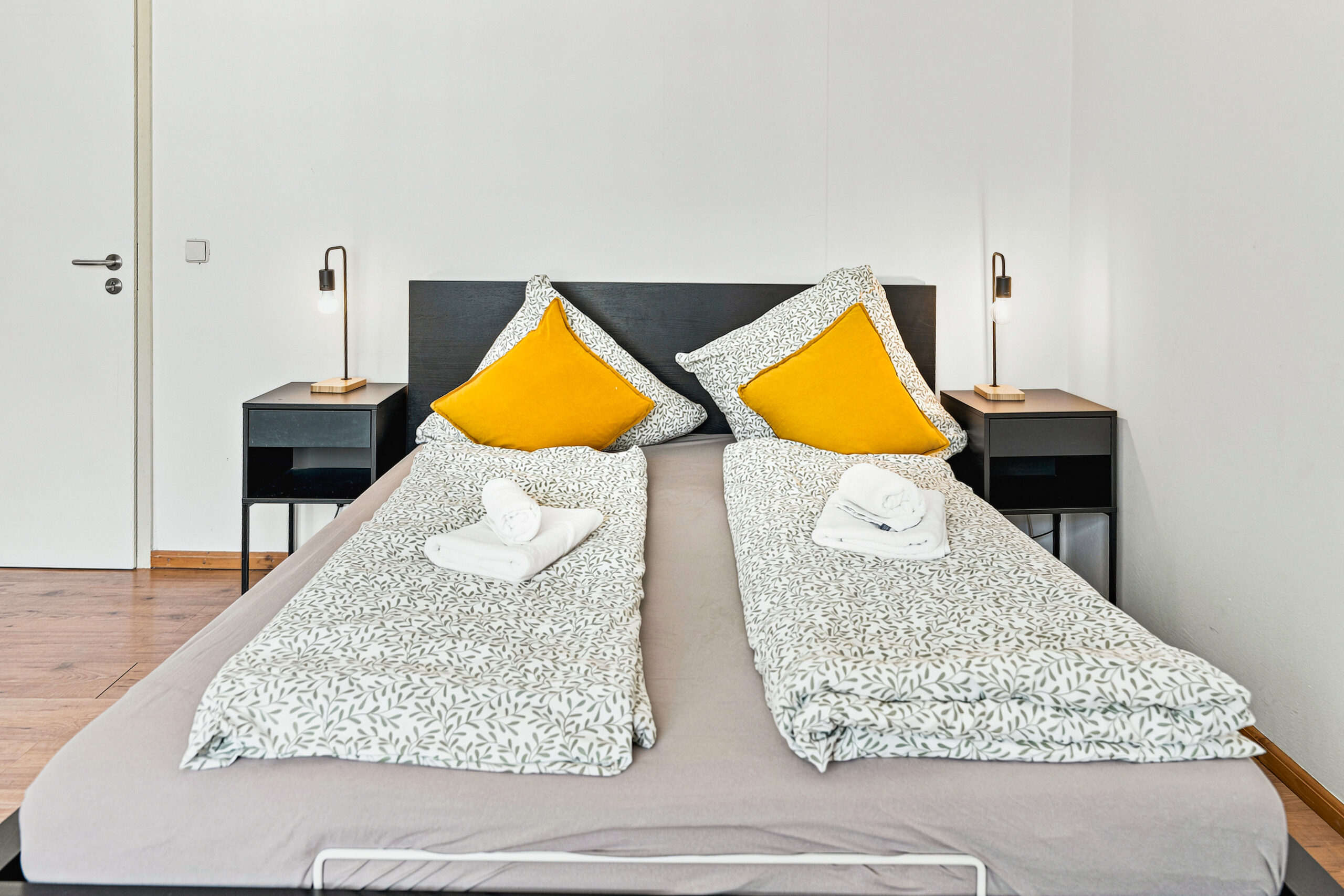 Close-up of bed with yellow pillows and geometric pattern bedding