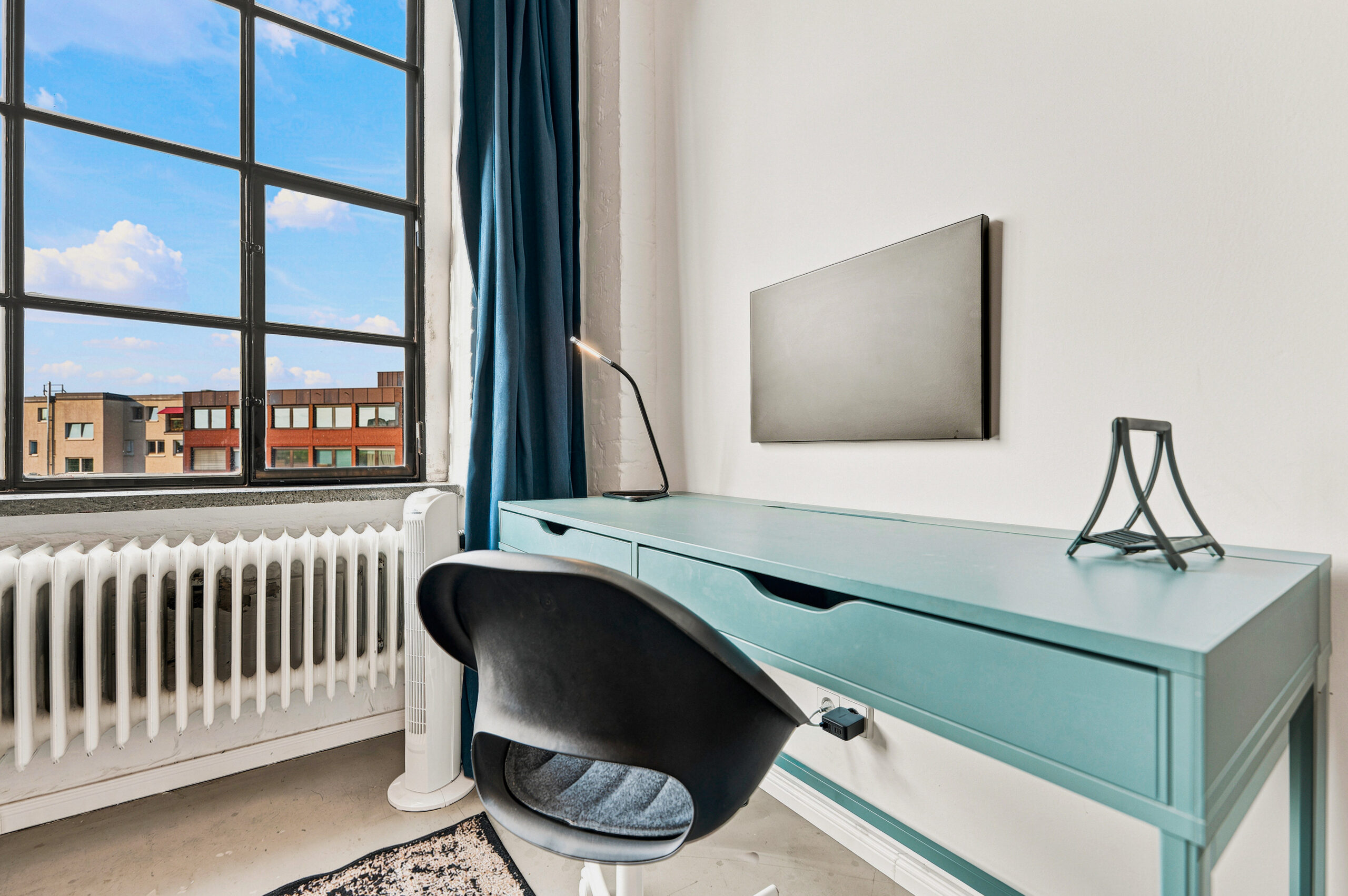 Modern bedroom desk area with turquoise details and window light