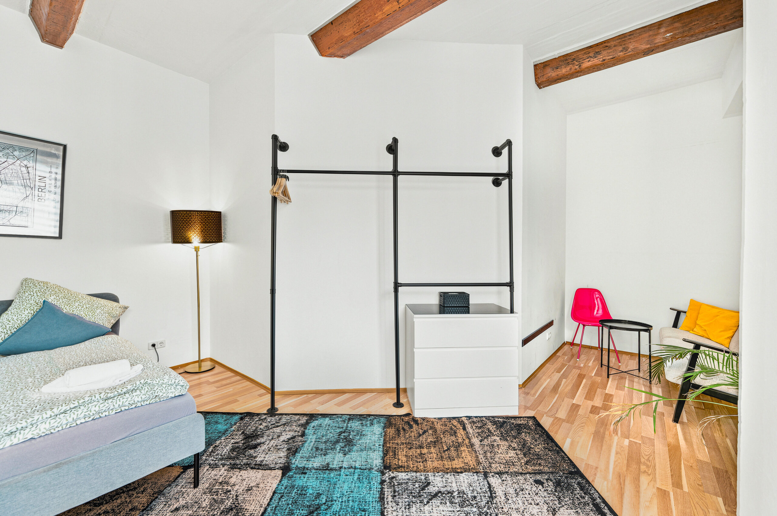 Bright bedroom with metal bed frame and hardwood flooring