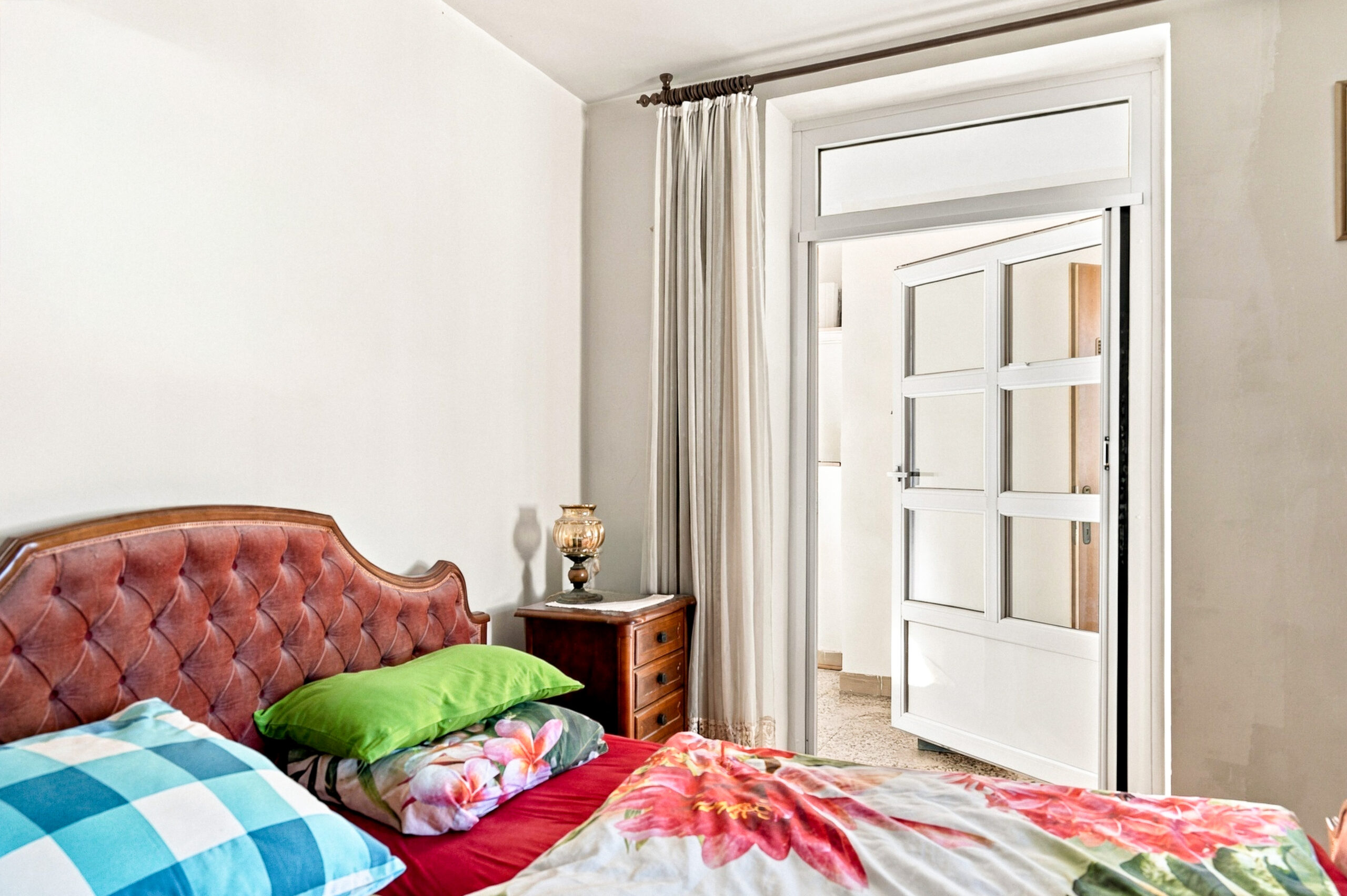 Bedroom with leather headboard and open door