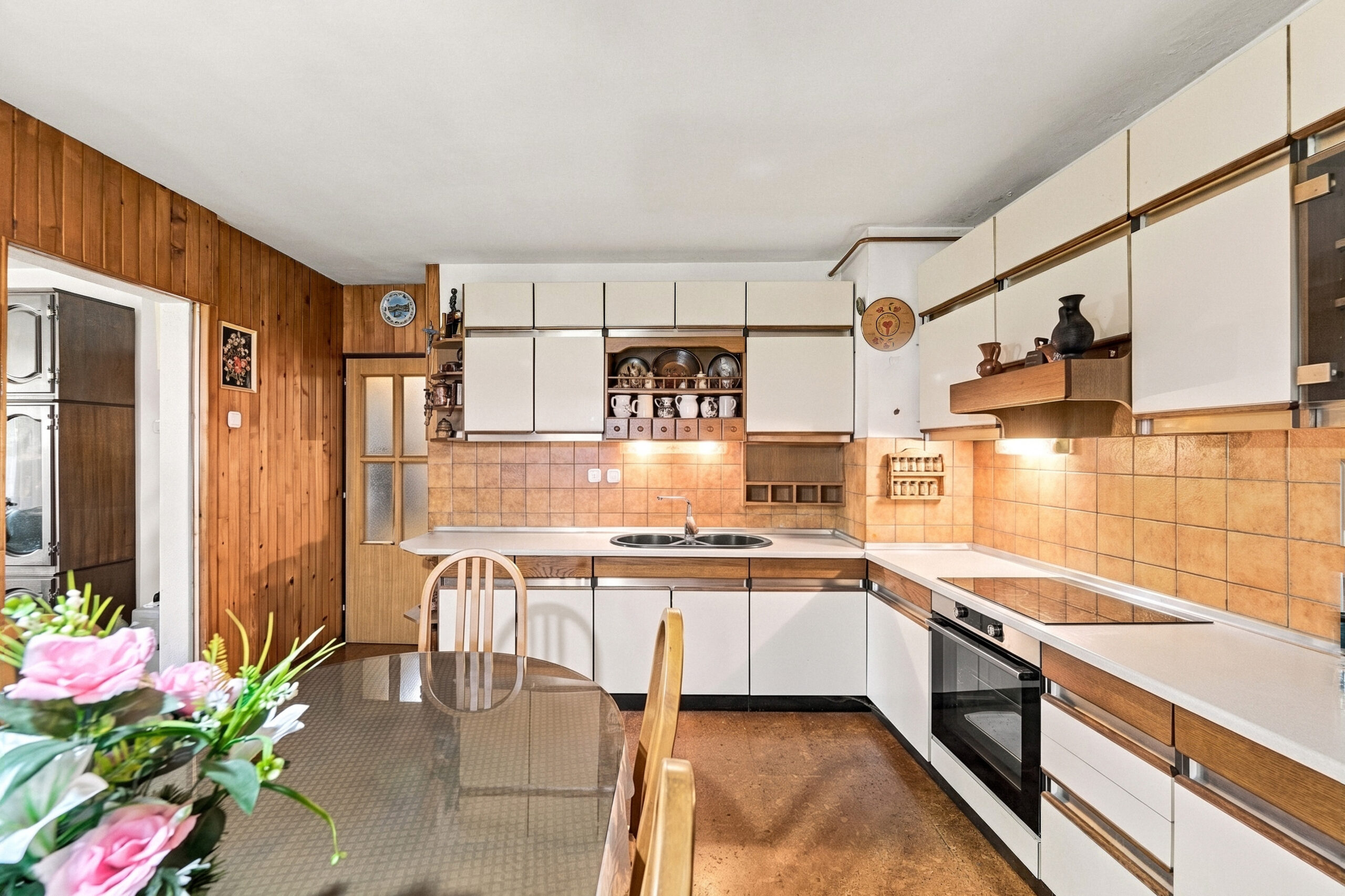 Wood paneled kitchen with white cabinets