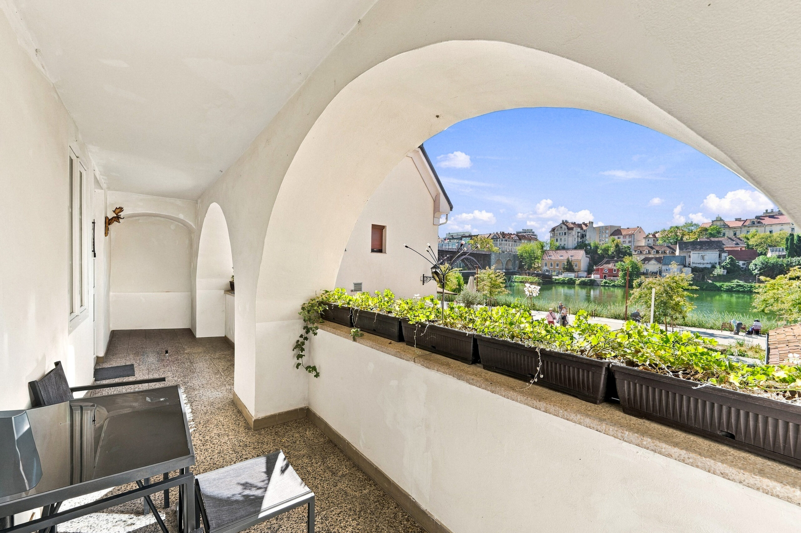 Arched balcony with seating and river view