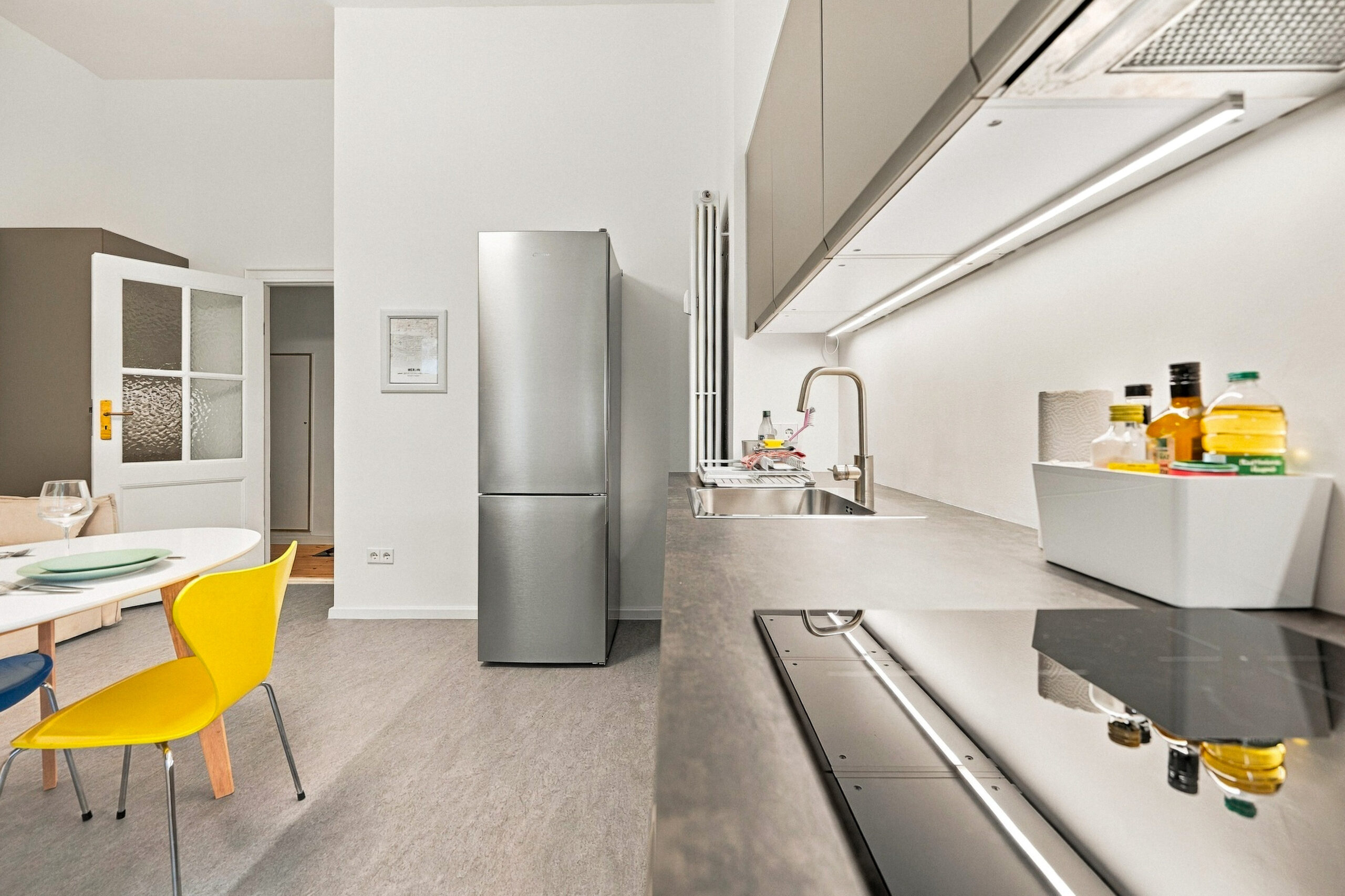 Kitchen with stainless fridge and dining table nearby