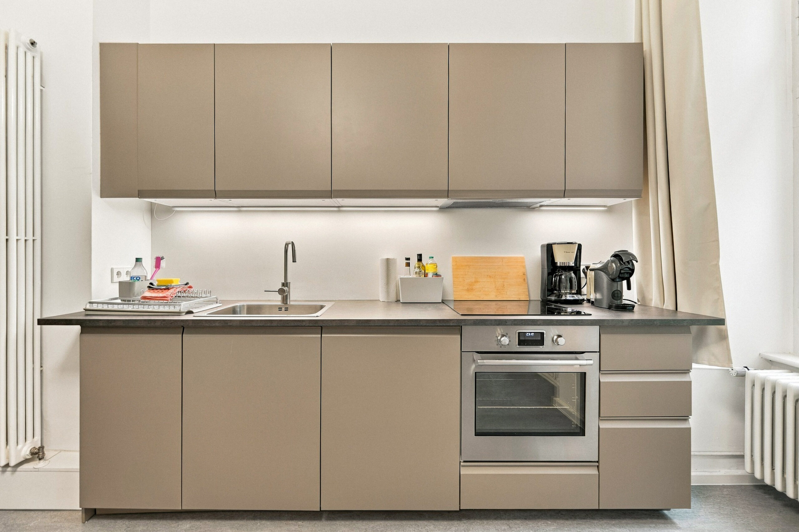 Sleek taupe kitchen with countertop and oven