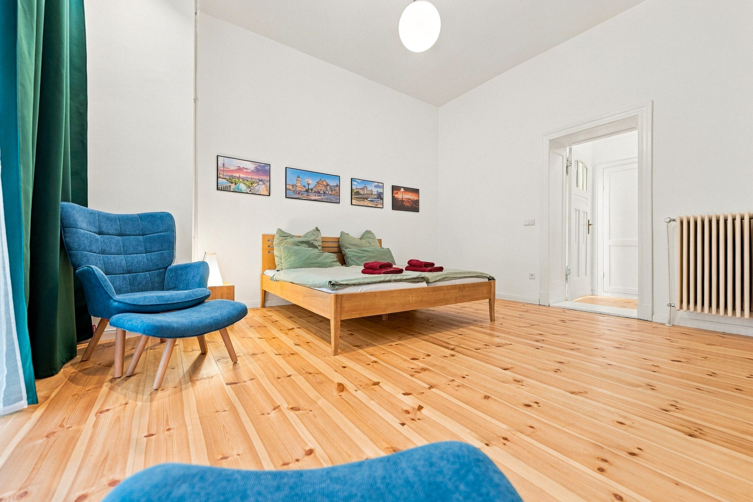 Bedroom corner with blue chair and artwork