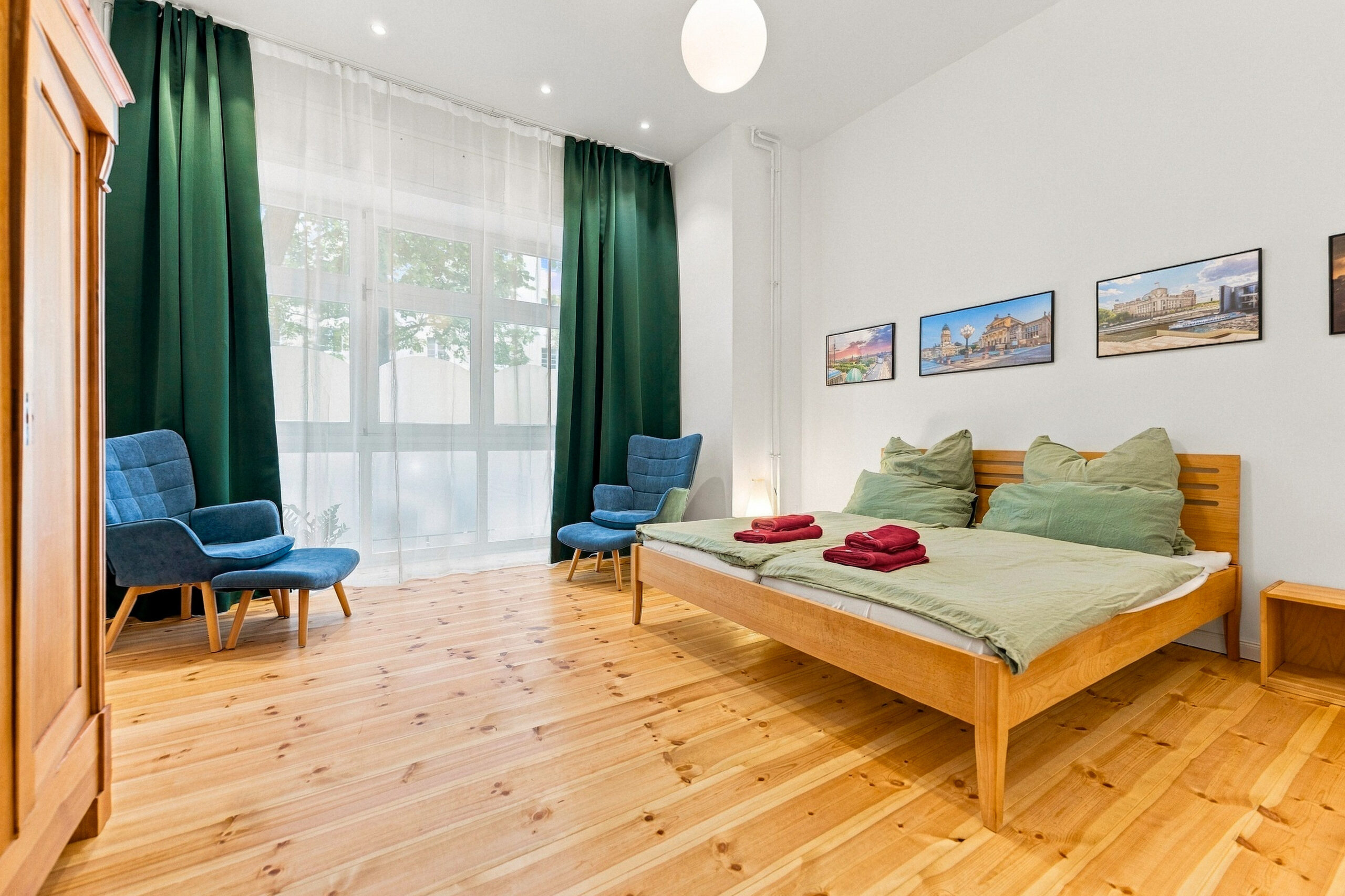 Bright bedroom with wood floor and blue chairs