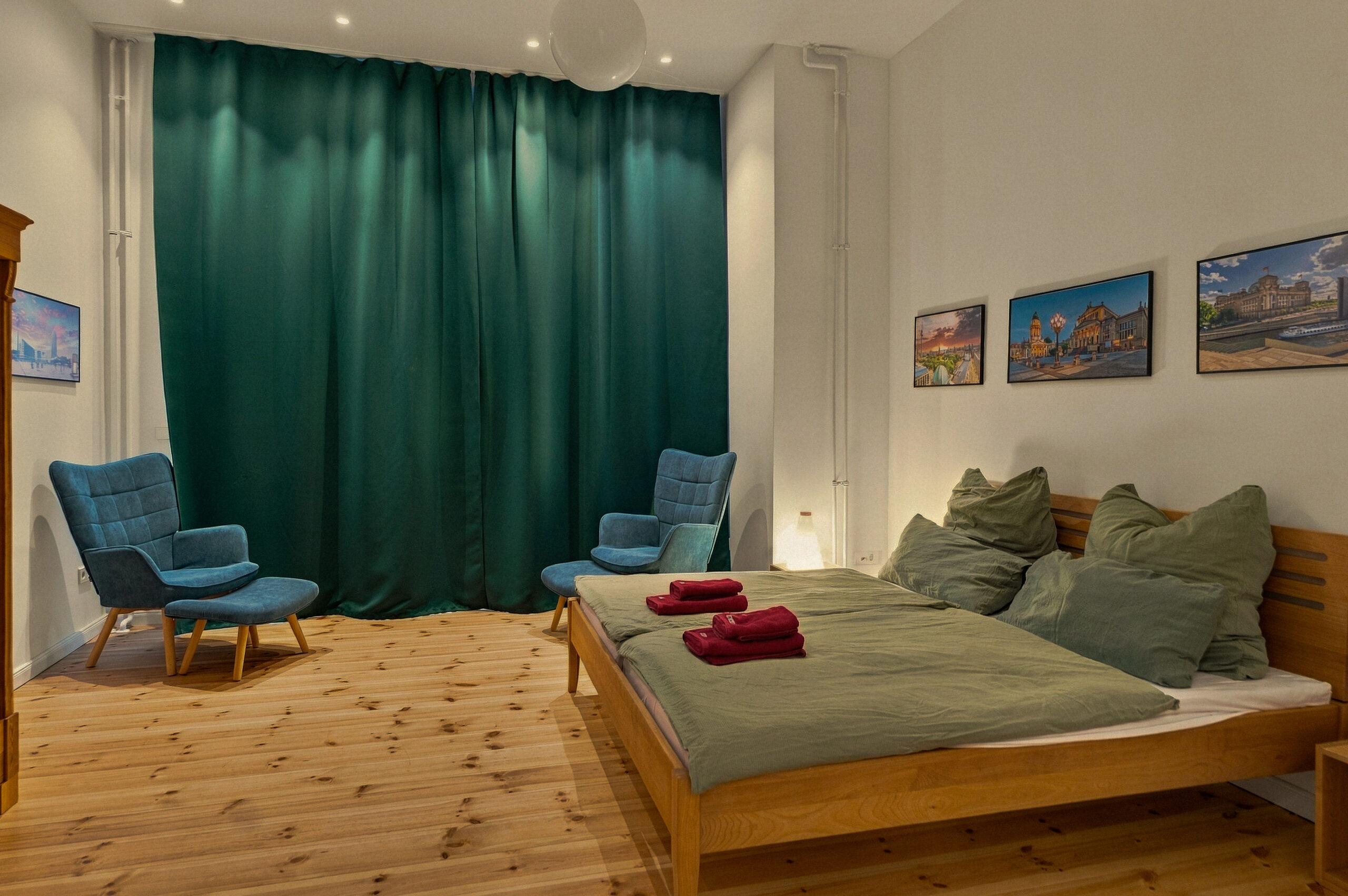 Bedroom with armchairs and green curtain backdrop