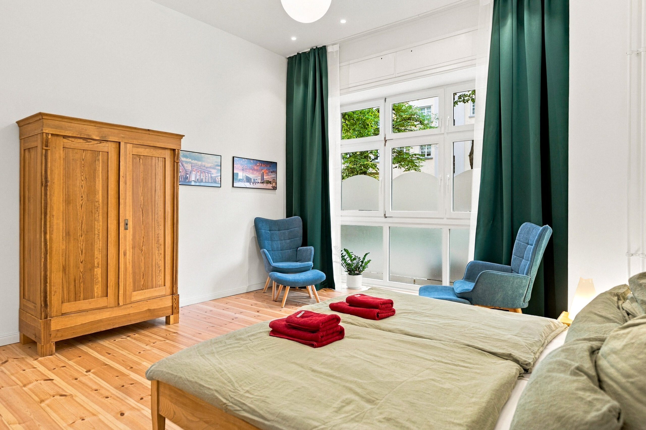 Bedroom with wardrobe, bed, and green curtains