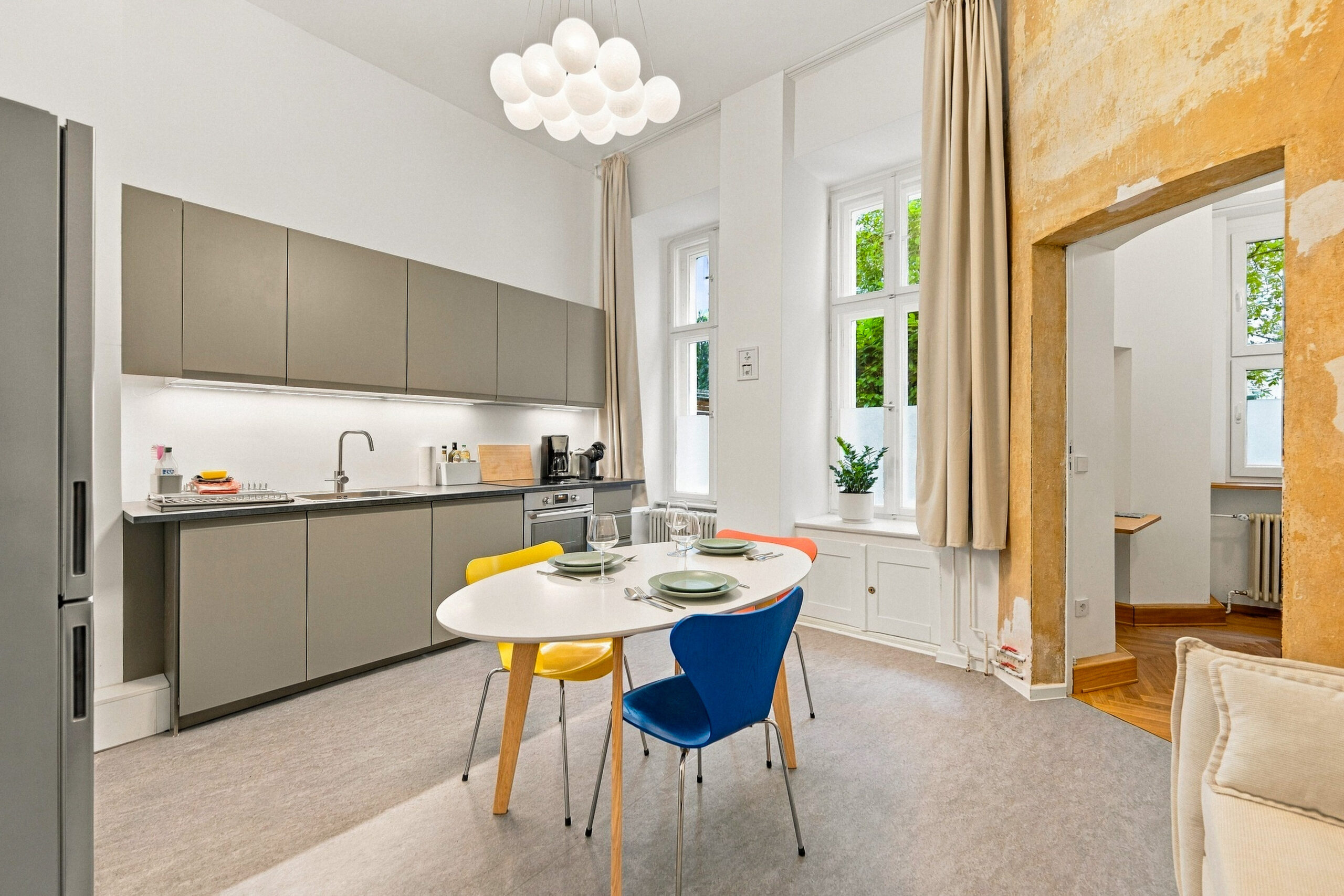 Dining table with colorful chairs under pendant light